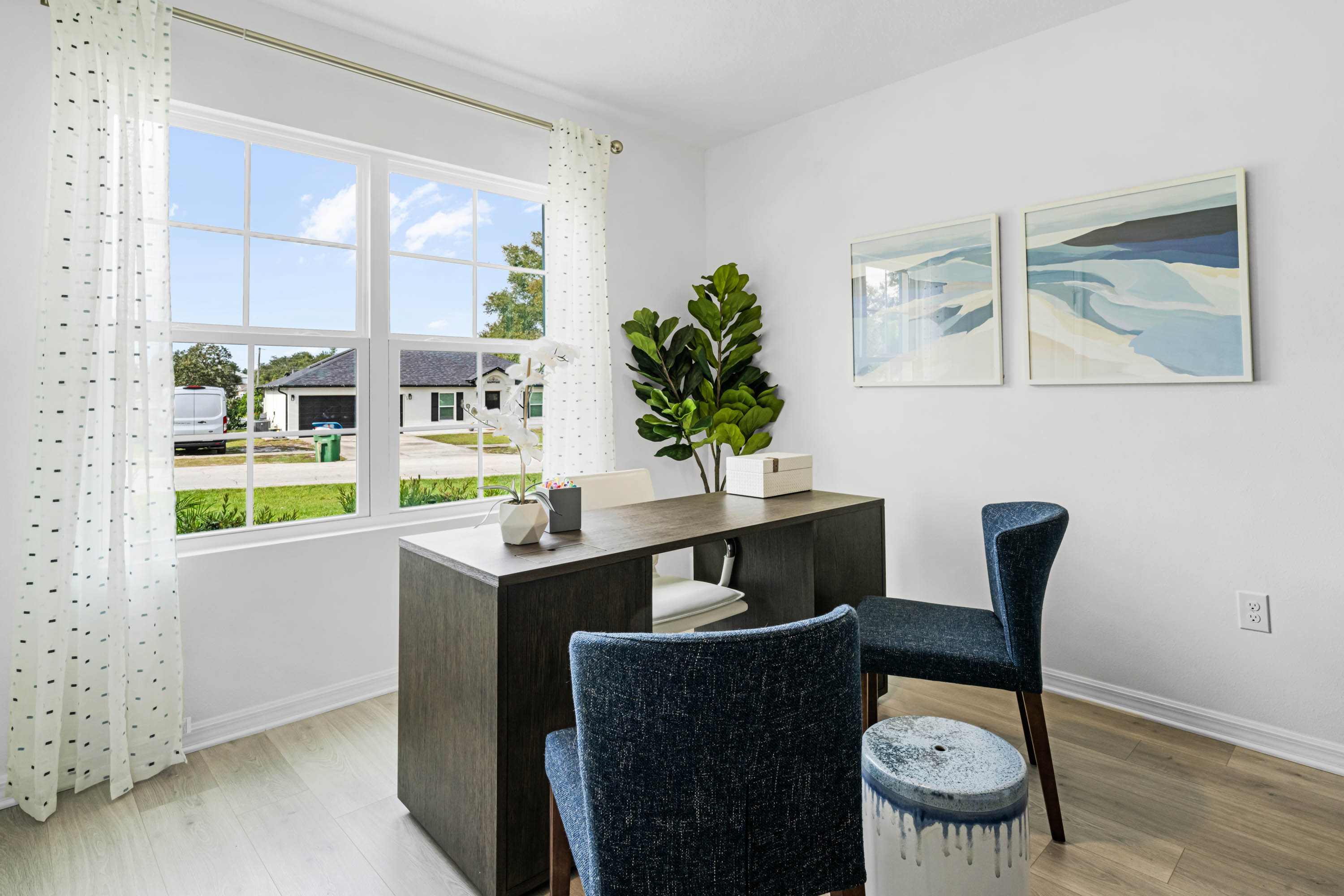 Multi-purpose office space with desk, seating and windows for natural lighting.