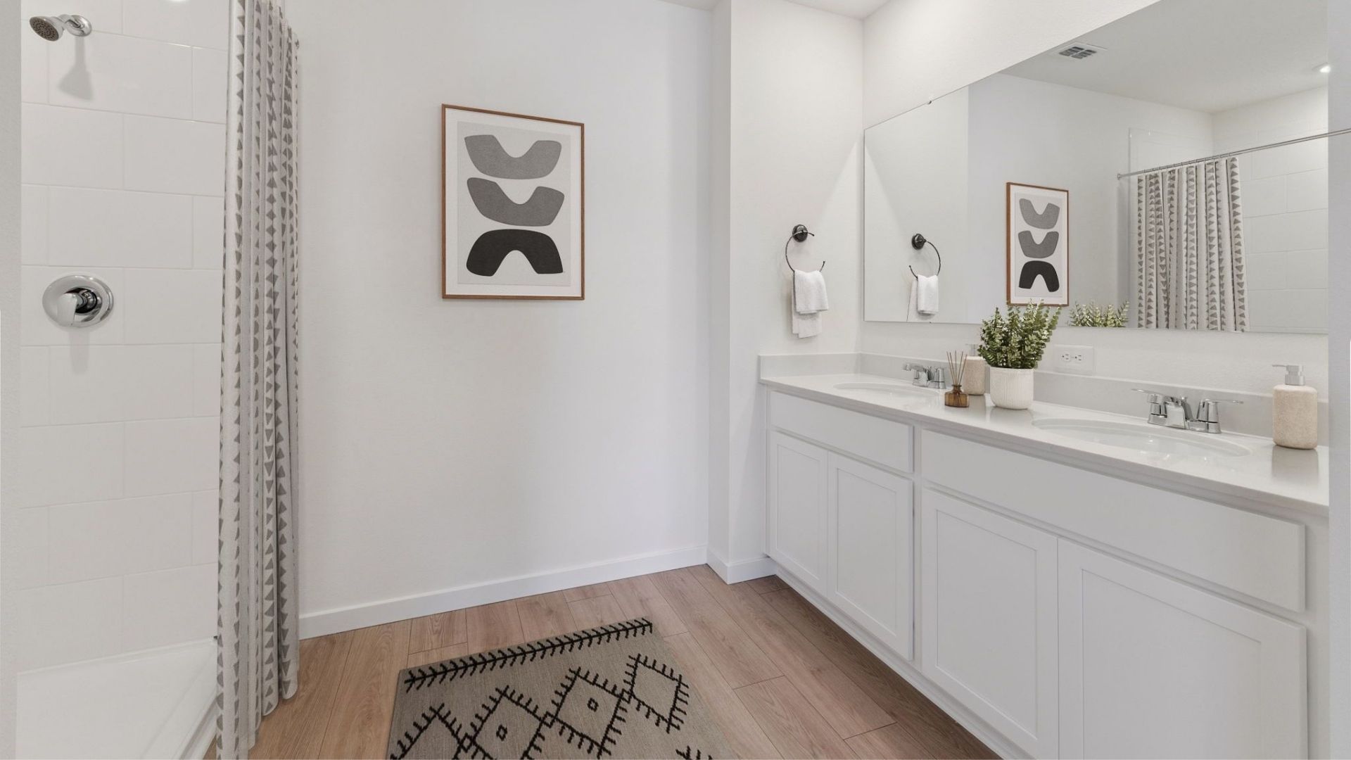 Modern bathroom with double vanity, large wall mirror, cabinets and quartz countertops