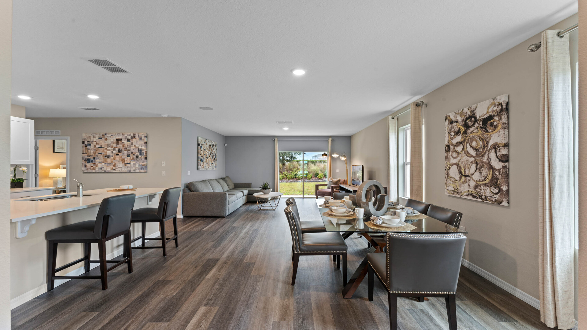 open concept with laminate flooring and living area, kitchen and dining room table