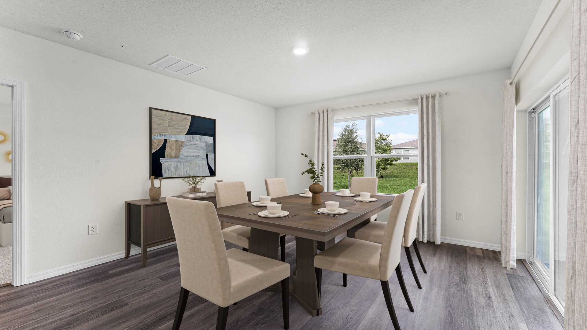 Dining room area with table, seating and natural lighting.