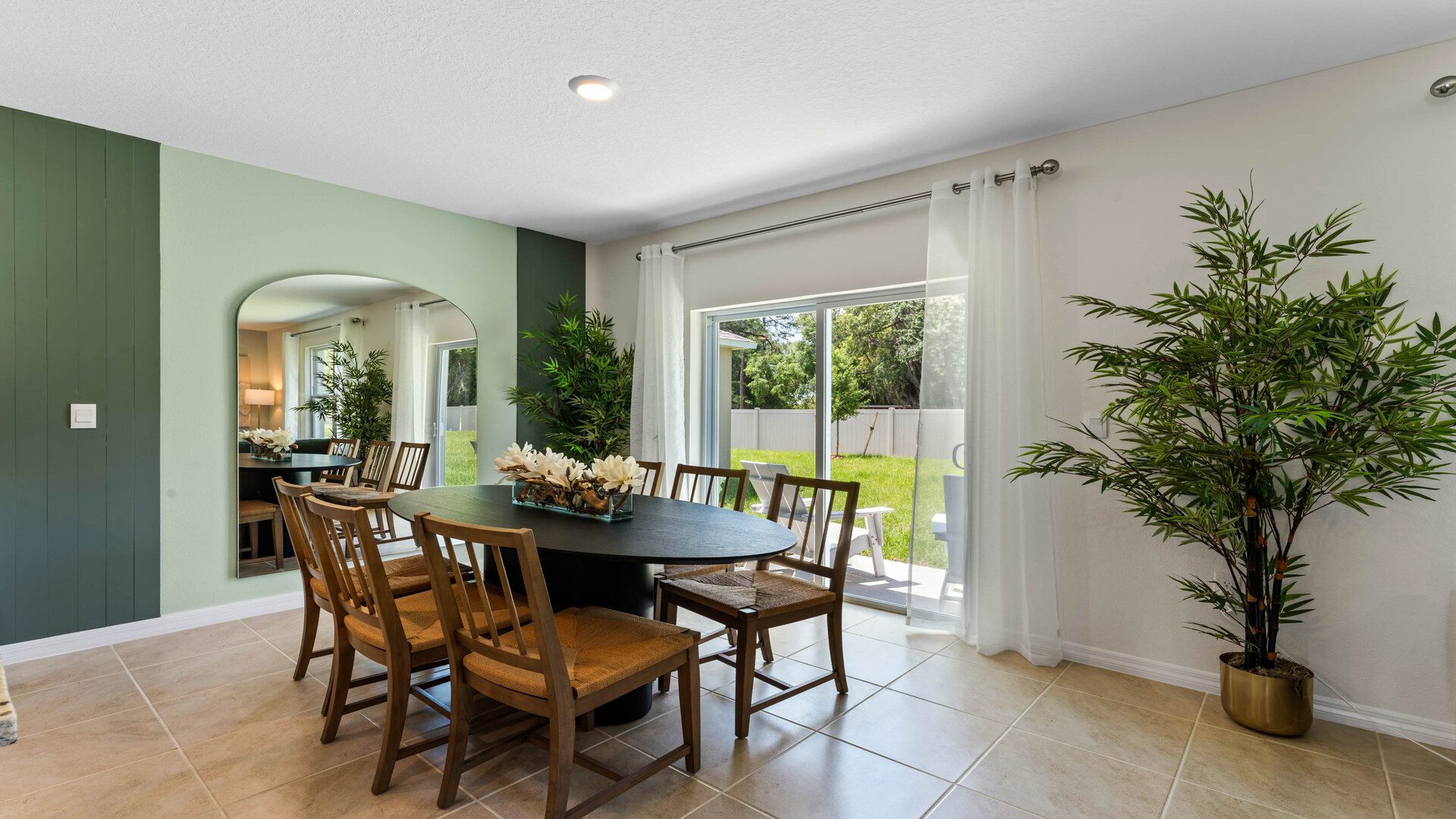 Dining room adjacent to the kitchen with table, chairs and tile flooring.