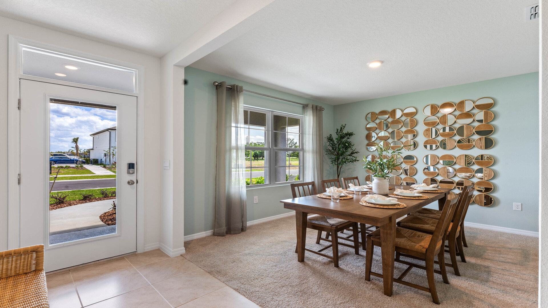 Dining room adjacent to the kitchen with table, chairs and tile flooring.