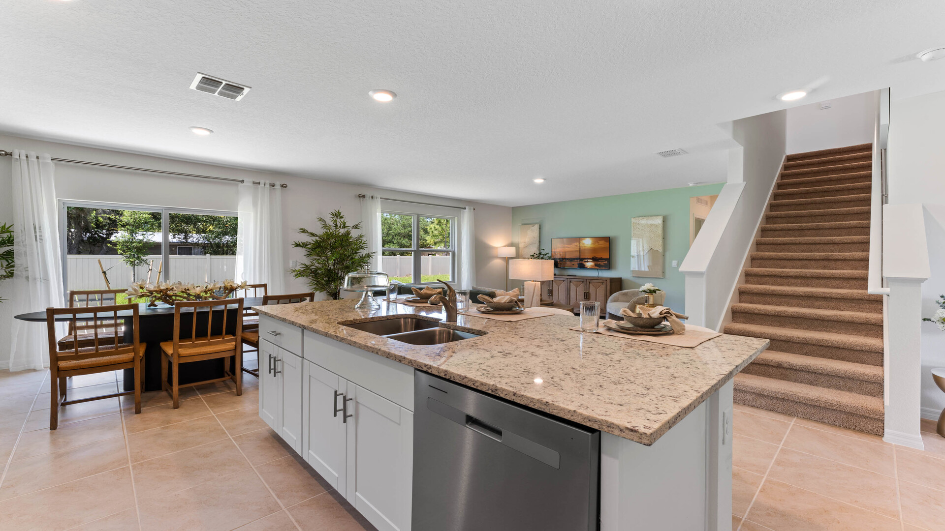 Kitchen with island seating, granite counters, spacious pantry and stainless-steel appliances.