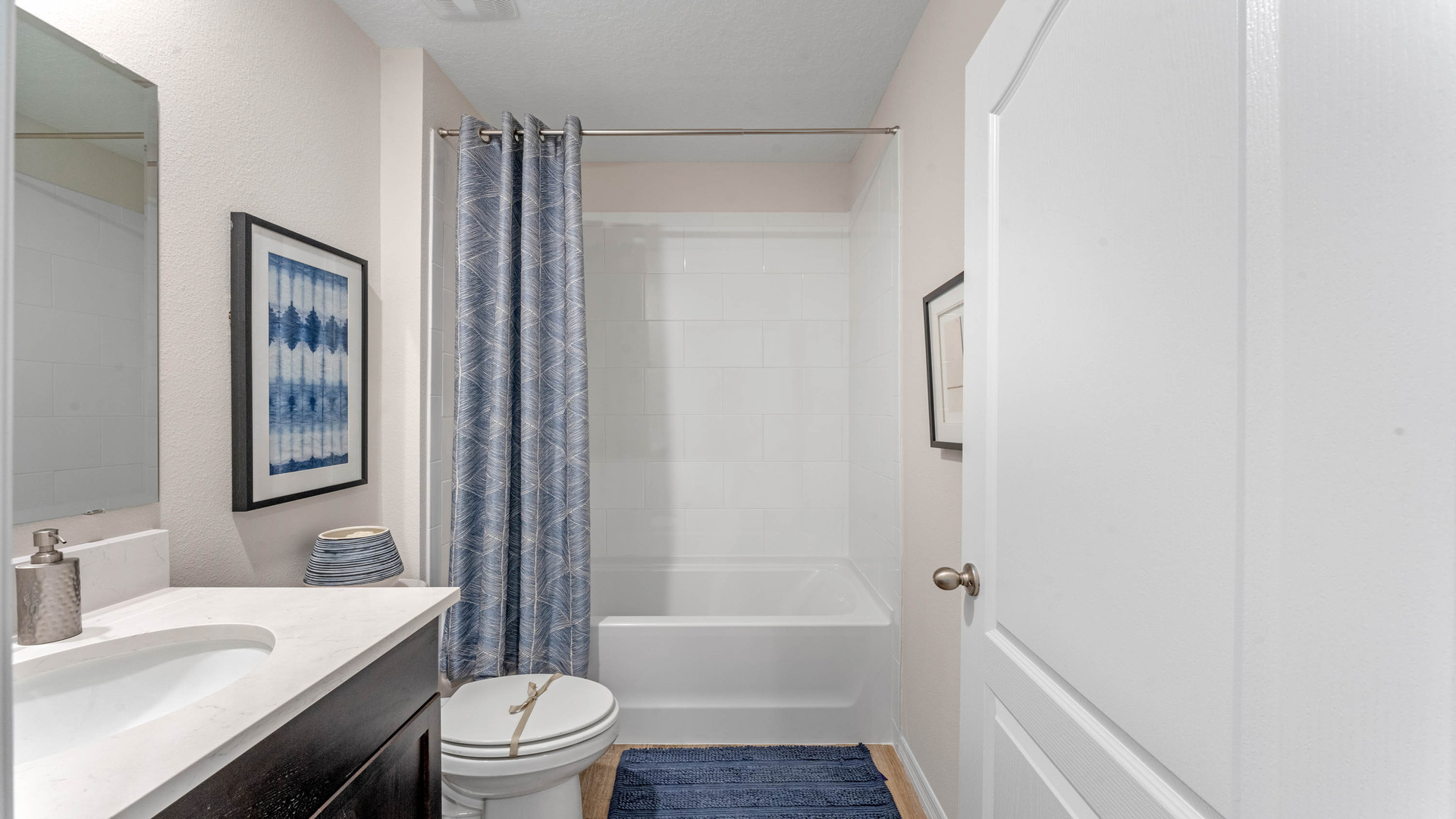 Modern bathroom with double vanity, large wall mirror, cabinets and quartz countertops