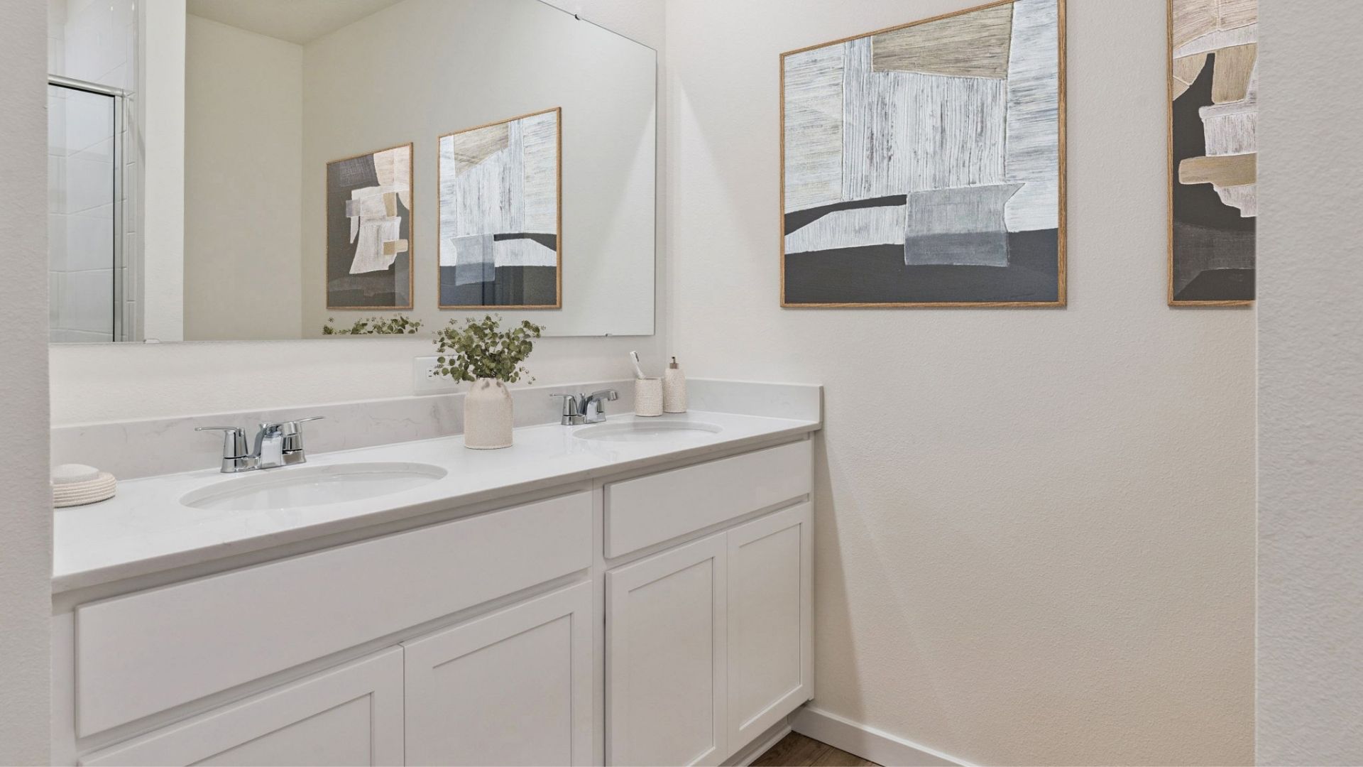 Modern bathroom with double vanity, large wall mirror, cabinets and quartz countertops
