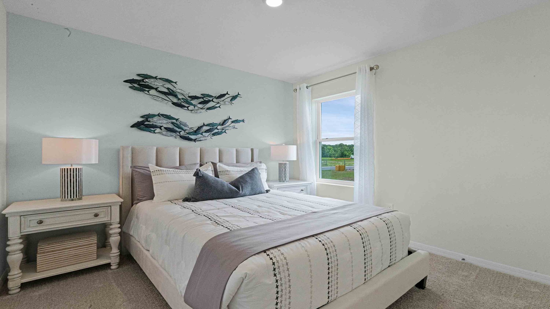 Guest bedroom with bed, nighstands and natural lighting.