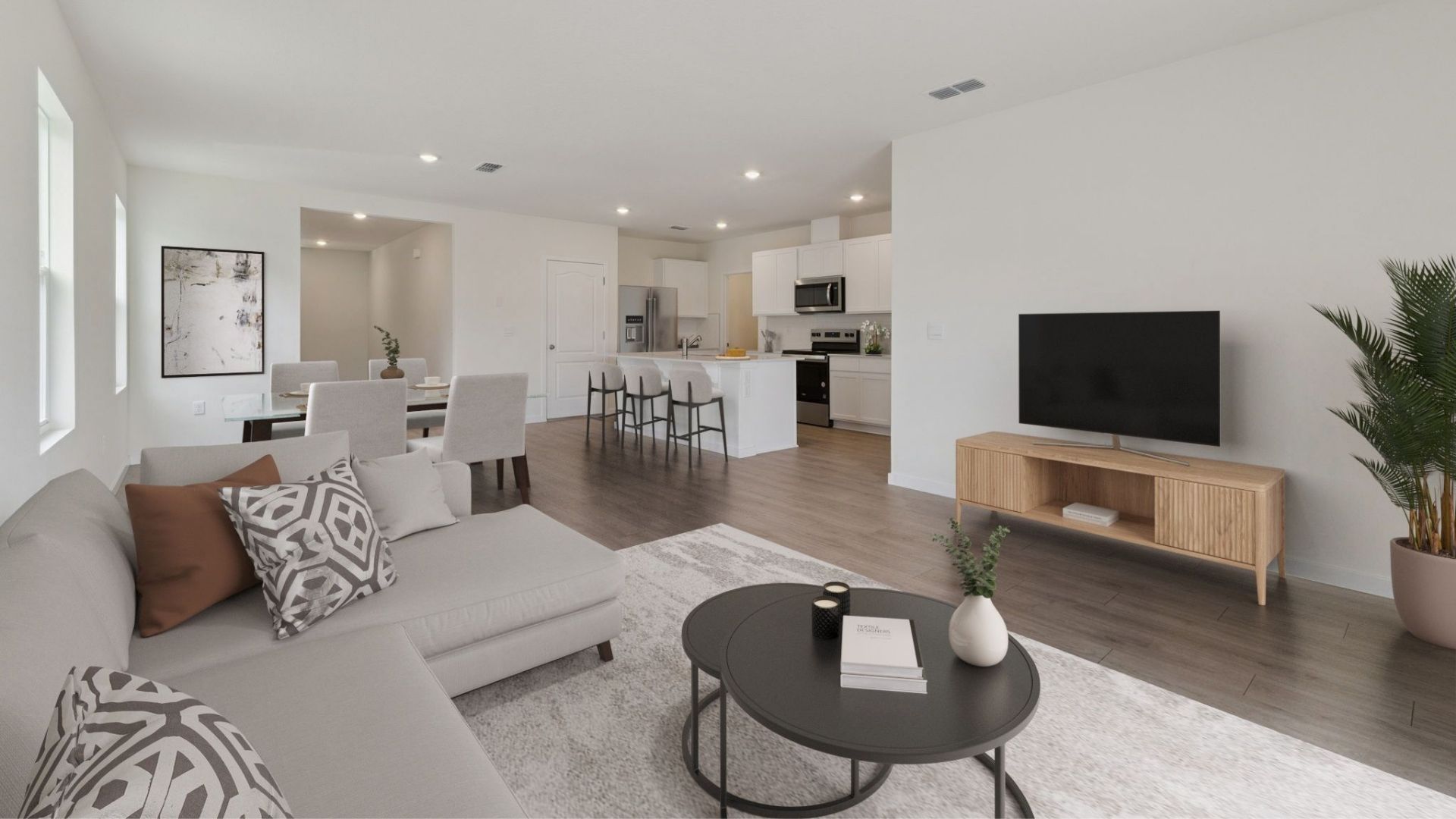Kitchen with island seating, quartz counters, spacious pantry and stainless steel appliances.