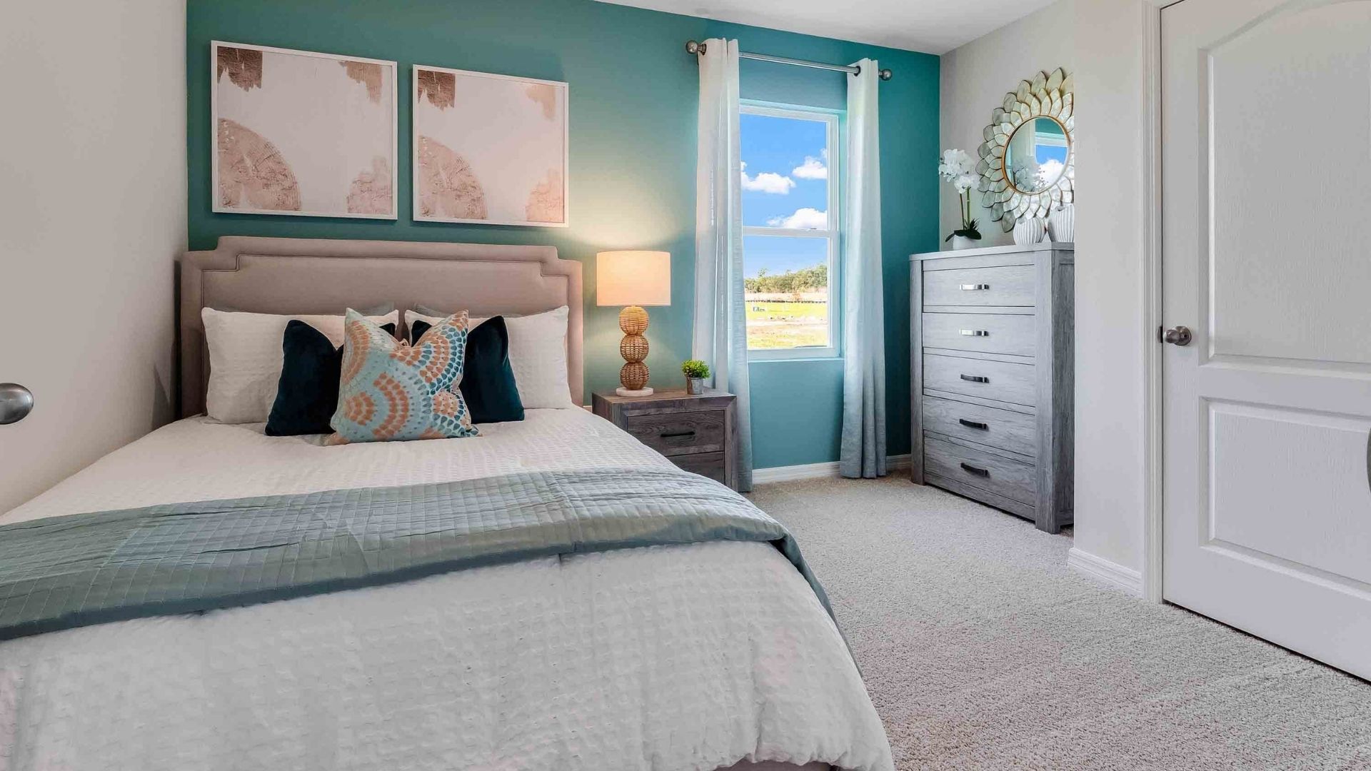 Spacious primary bedroom with king size bed, carpet flooring, natural lighting.