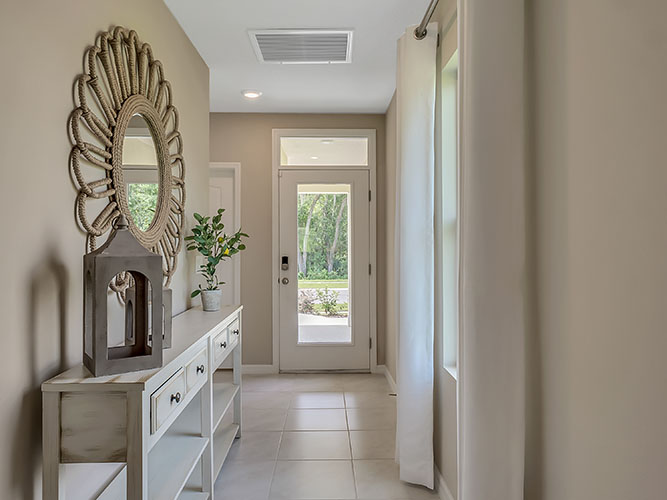 Home entry way thru the front door with tile flooring and front door.