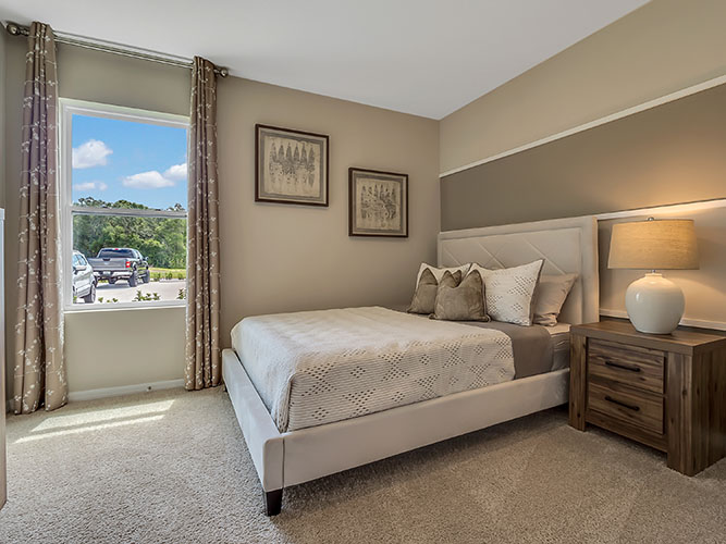 Guest bedroom with bed, nighstands and natural lighting.