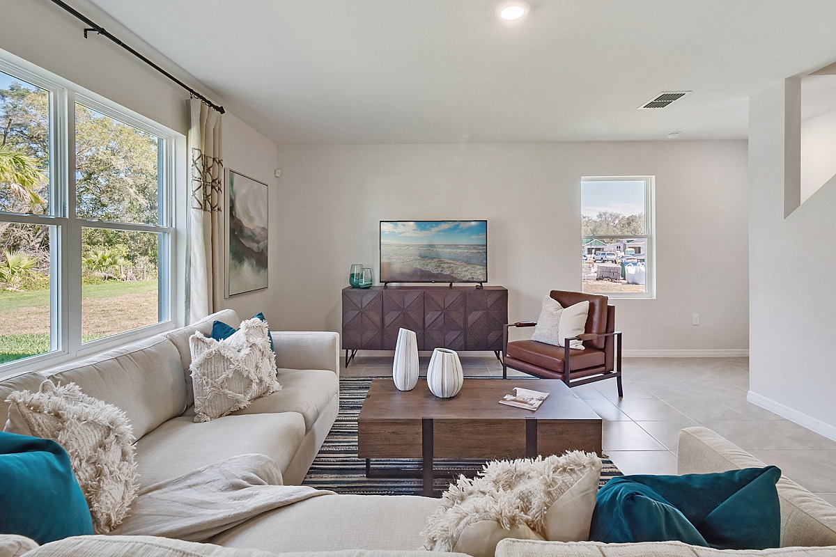 Living area with couch seating, natural lighting, luxury vinyl plank flooring.