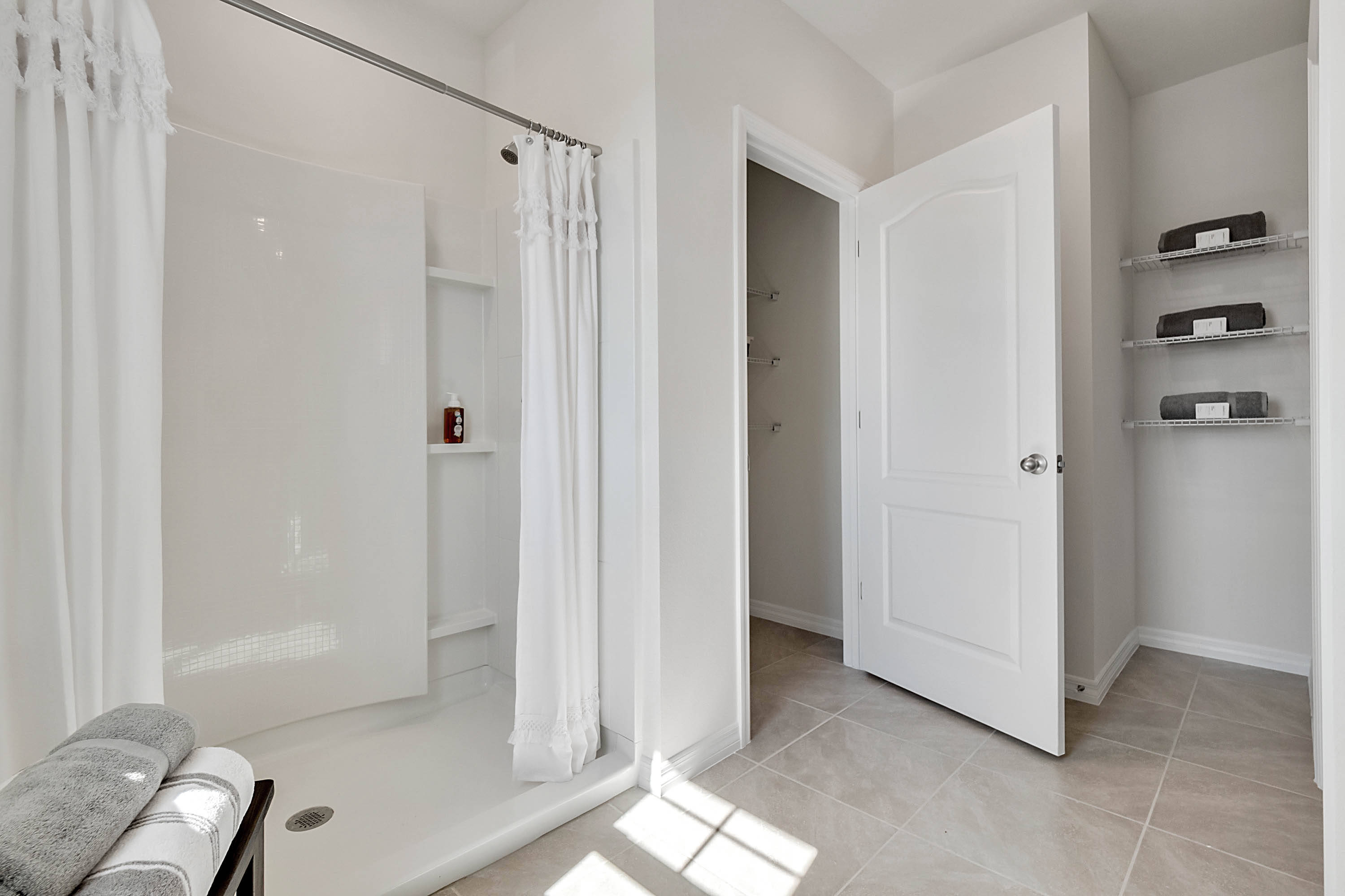 Guest bathroom showing single vanity sinks with quartz countertops, large mirror, and toilet.