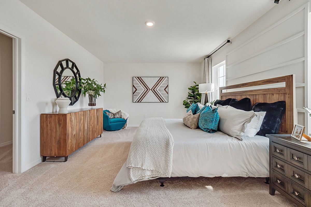 Guest bedroom with bed, nighstand, desk, and natural lighting with spacious closet.