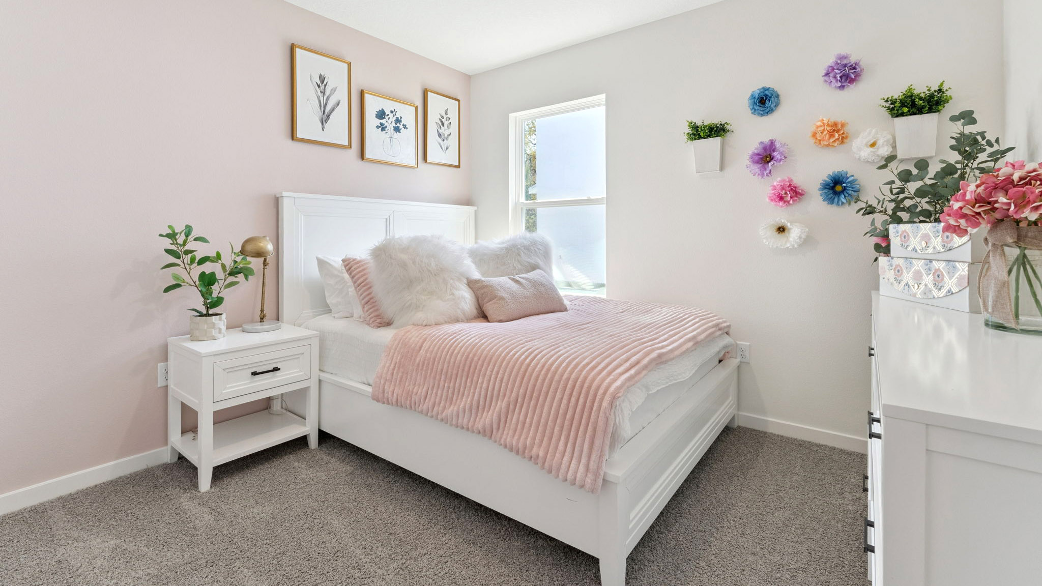 Spacious primary bedroom with king size bed, carpet flooring, natural lighting.