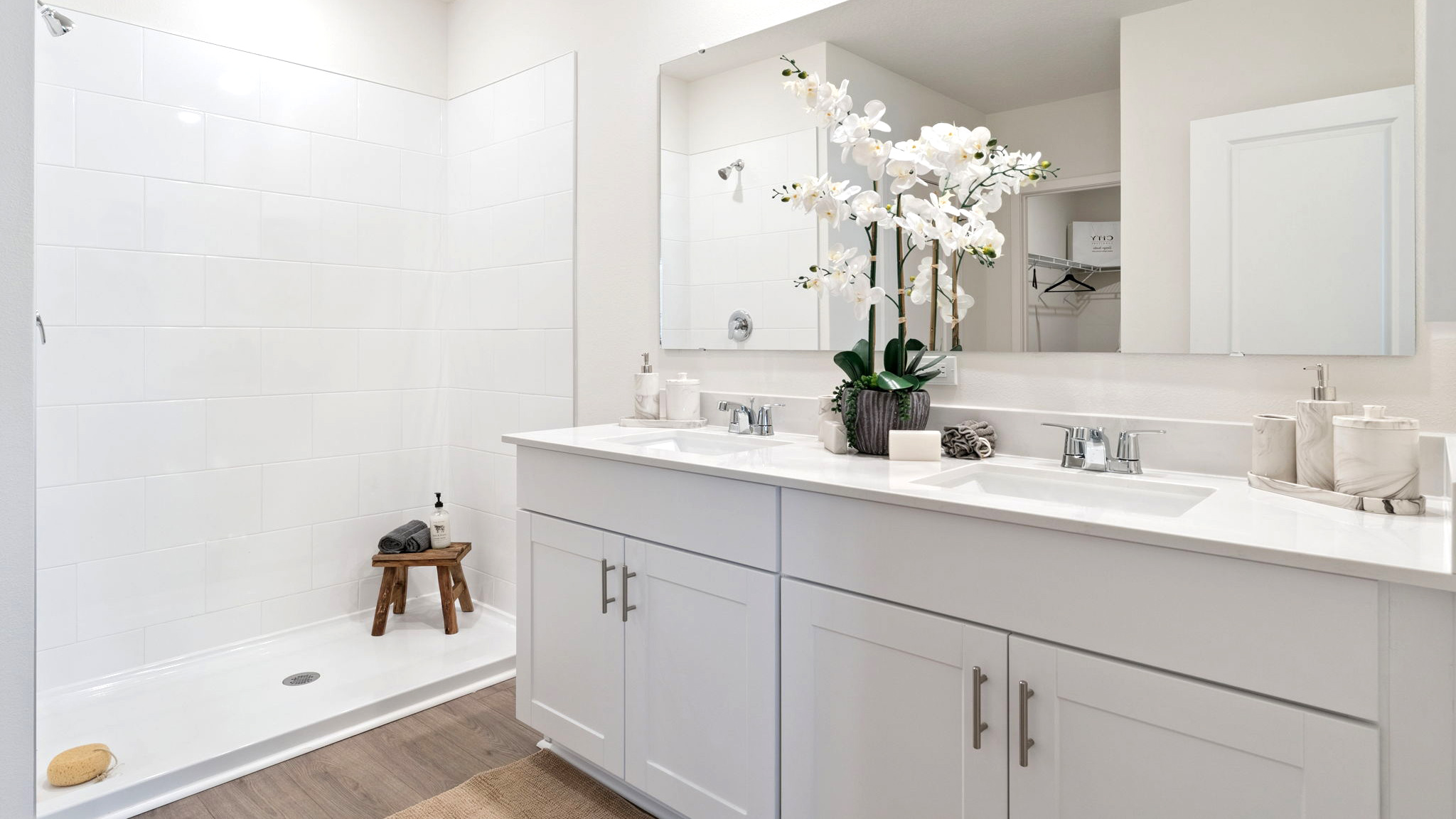 Modern bathroom with single vanity, large wall mirror, cabinets and quartz countertops