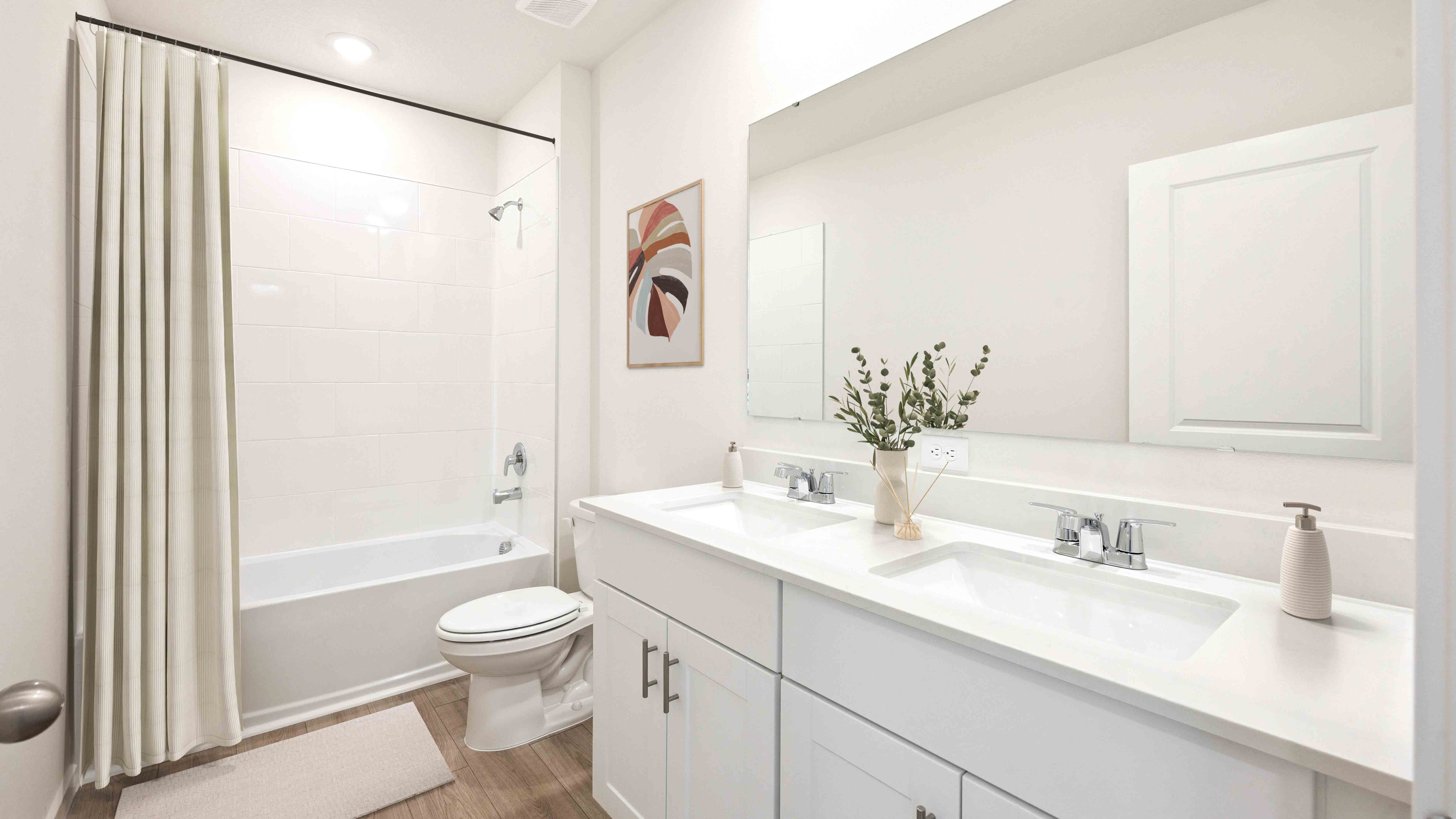 Modern bathroom with double vanity, large wall mirror, cabinets and quartz countertops