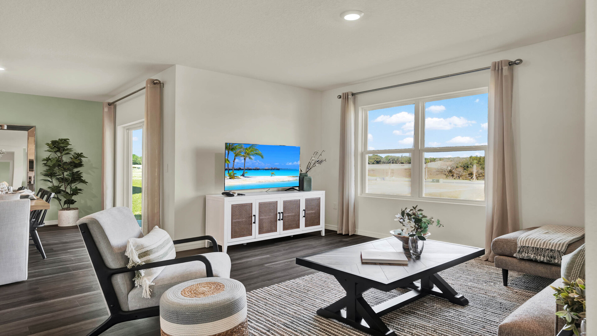 Living area with couch seating, entertainment system and natural lighting.