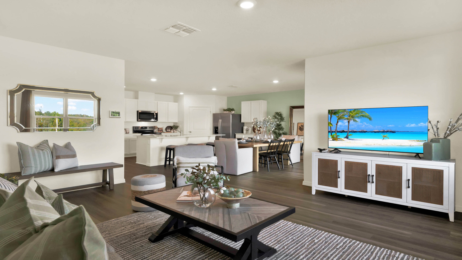 Living area with couch seating, entertainment system and natural lighting.