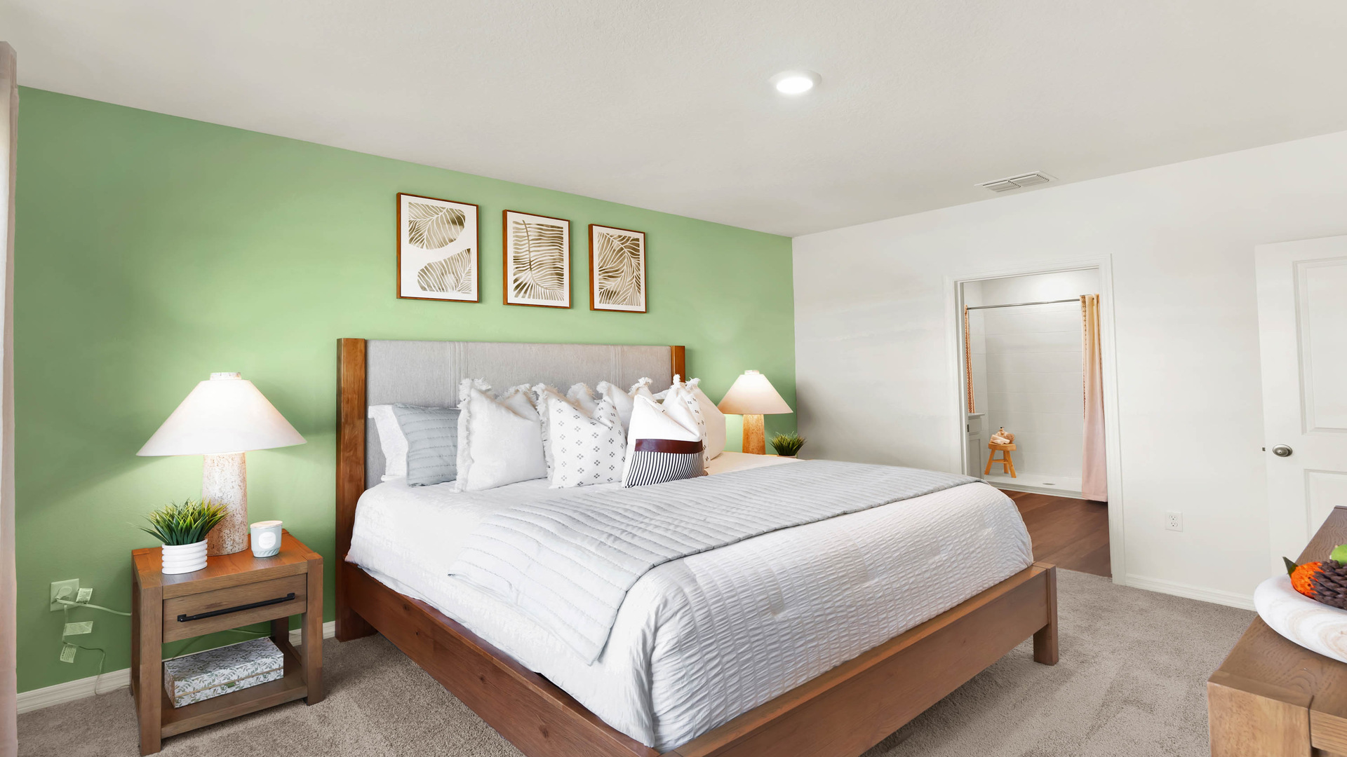 Spacious primary bedroom with king size bed, carpet flooring, natural lighting showing access to master bathroom.