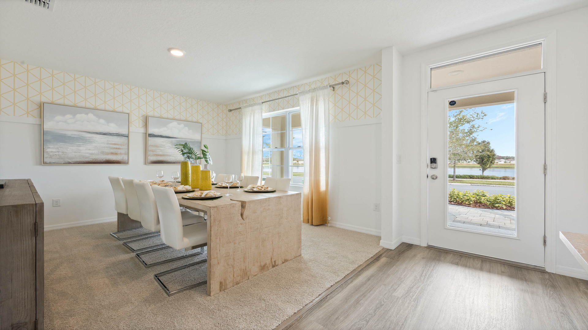 Entry to home showing front door with luxury vinyl plank flooring overseeing dining room table.