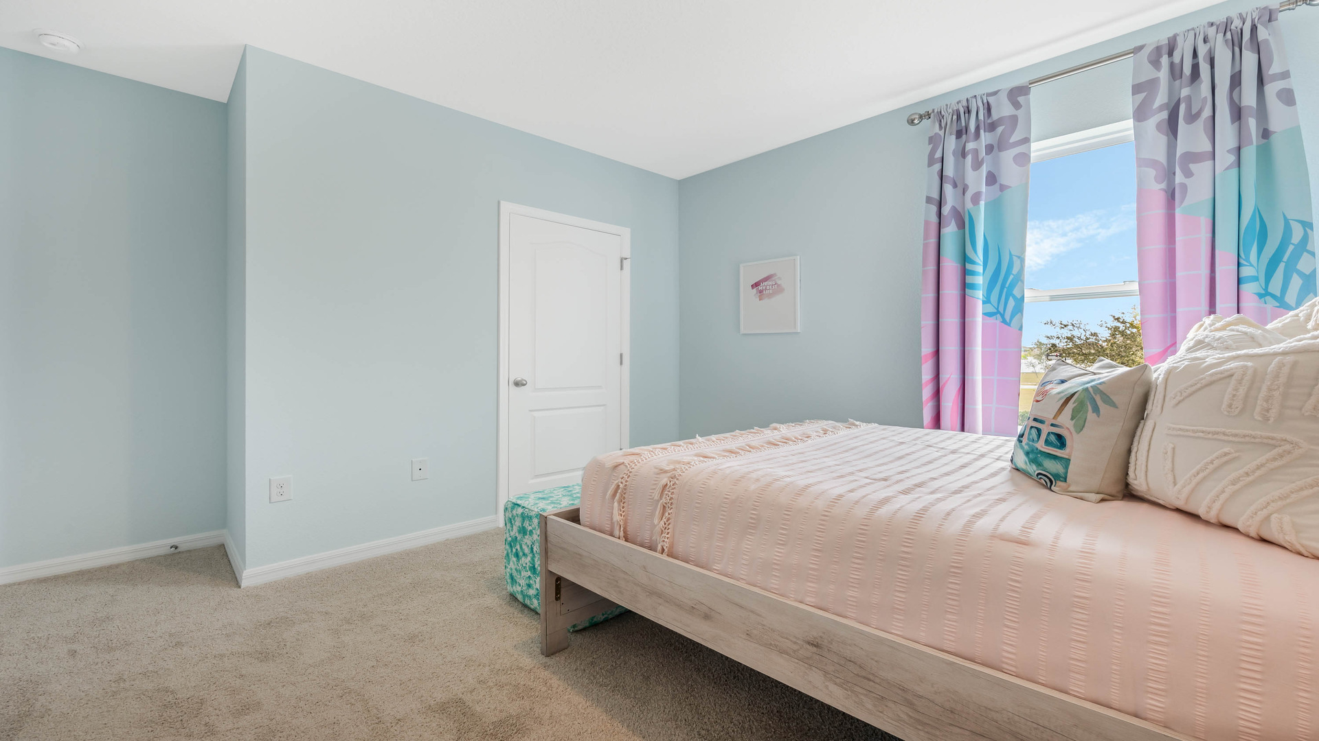 Guest bedroom with bed, nighstands and natural lighting.
