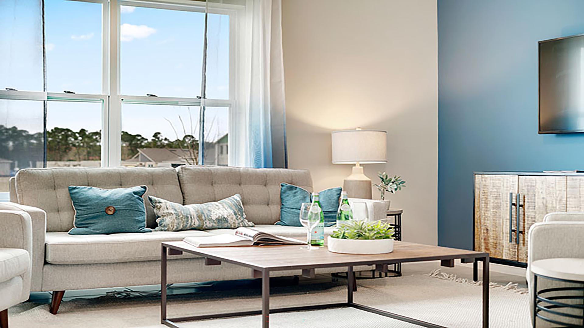 Living area with couch seating, natural lighting adjacent to kitchen and dinette.