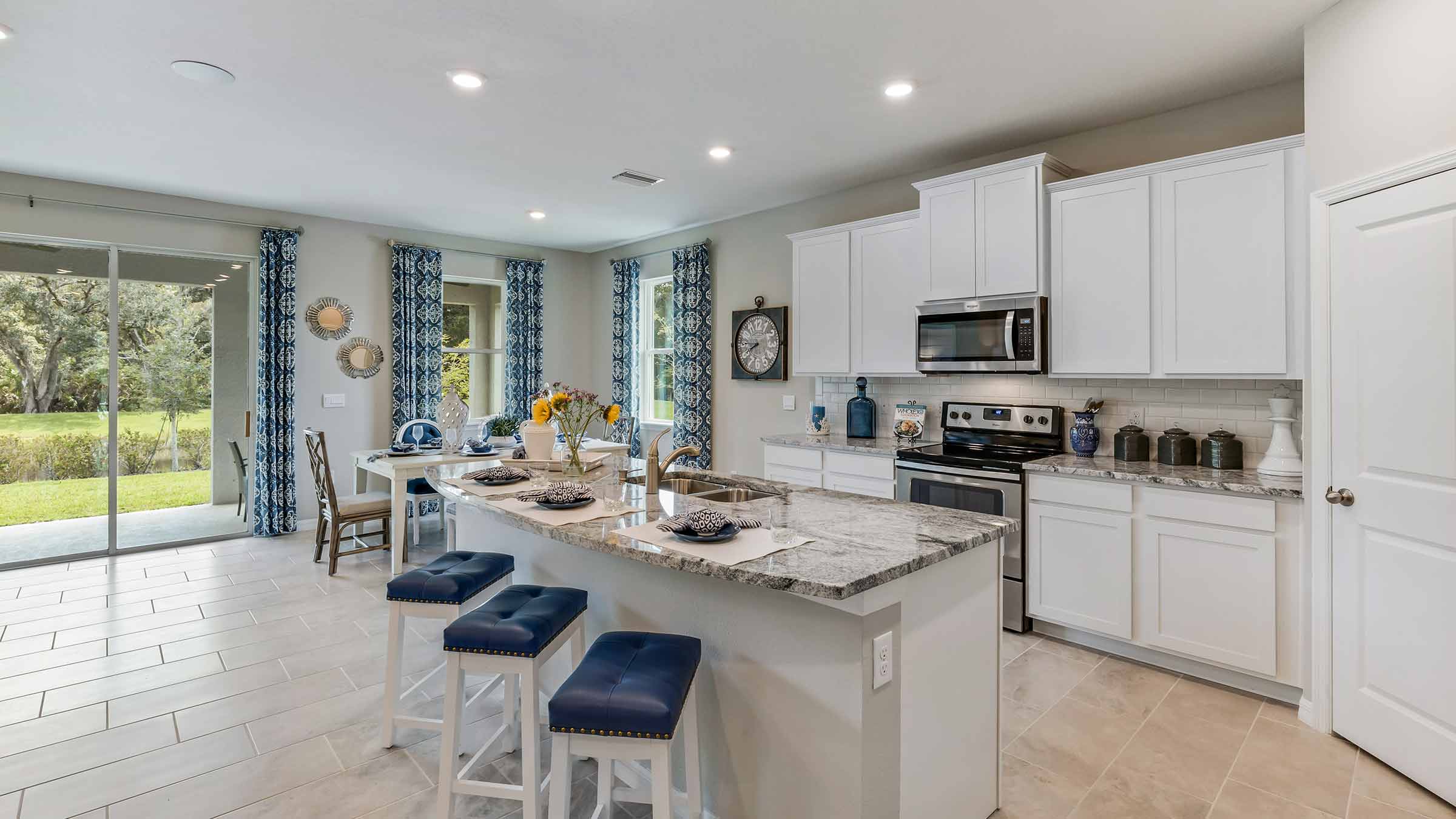 Kitchen with island and white cabinets and stainless steel appliances
