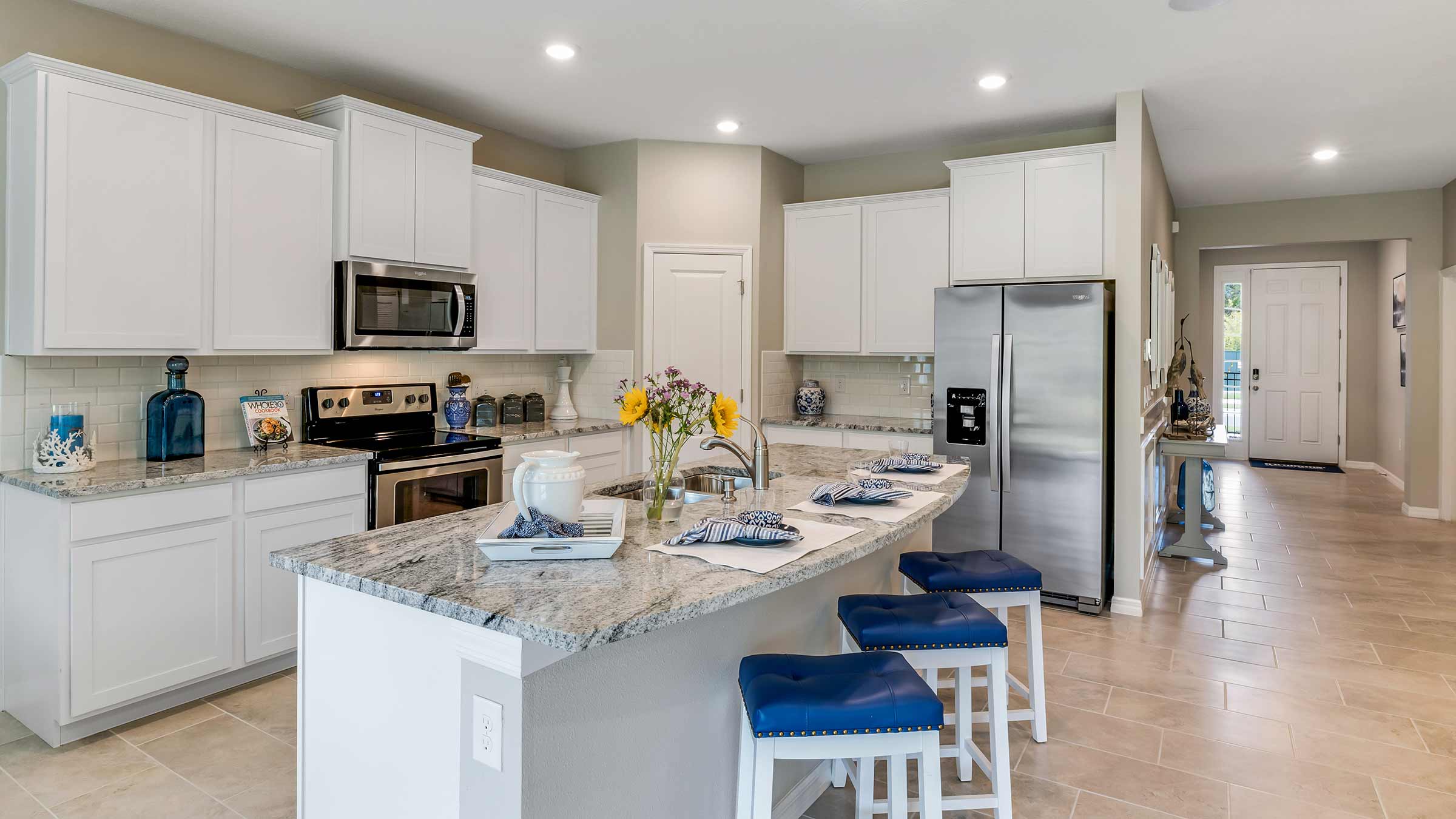 Kitchen with island and white cabinets and stainless steel appliances