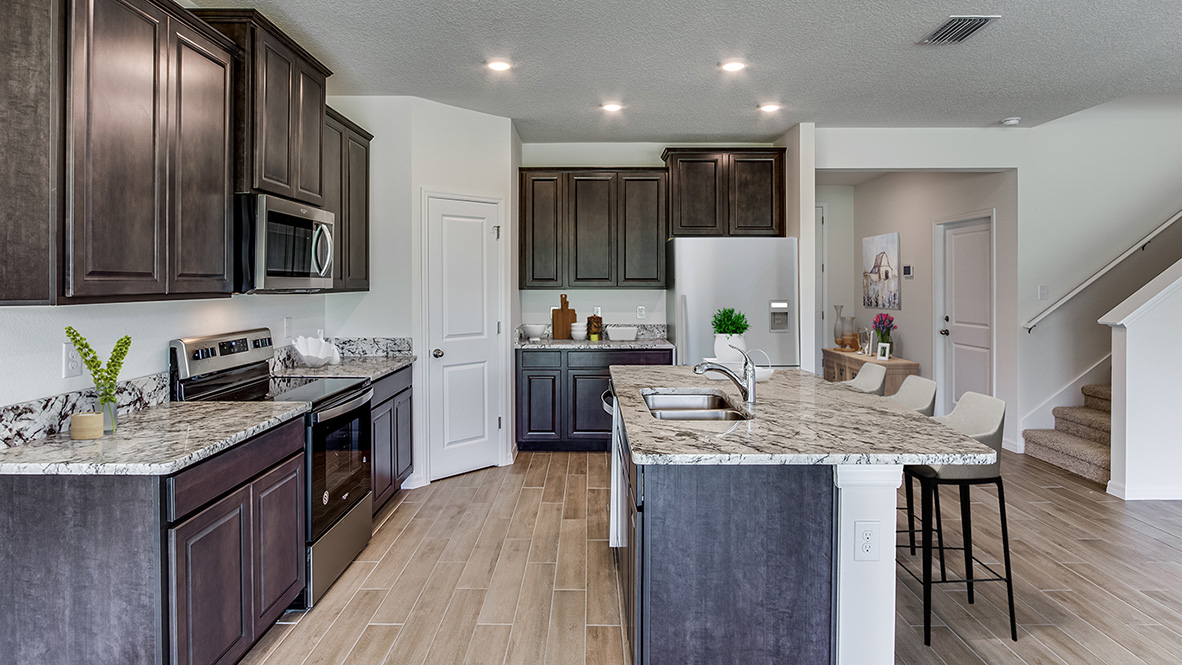 Kitchen with island and dark cabinets and stainless steel appliances