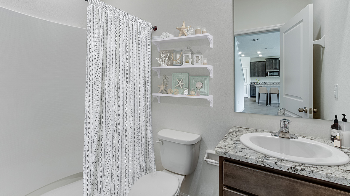 Bathroom with shower and sink and dark cabinet and window