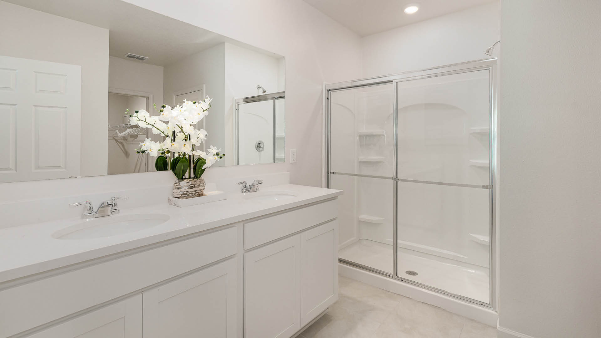 Primary bathroom with double vanity and walk in shower