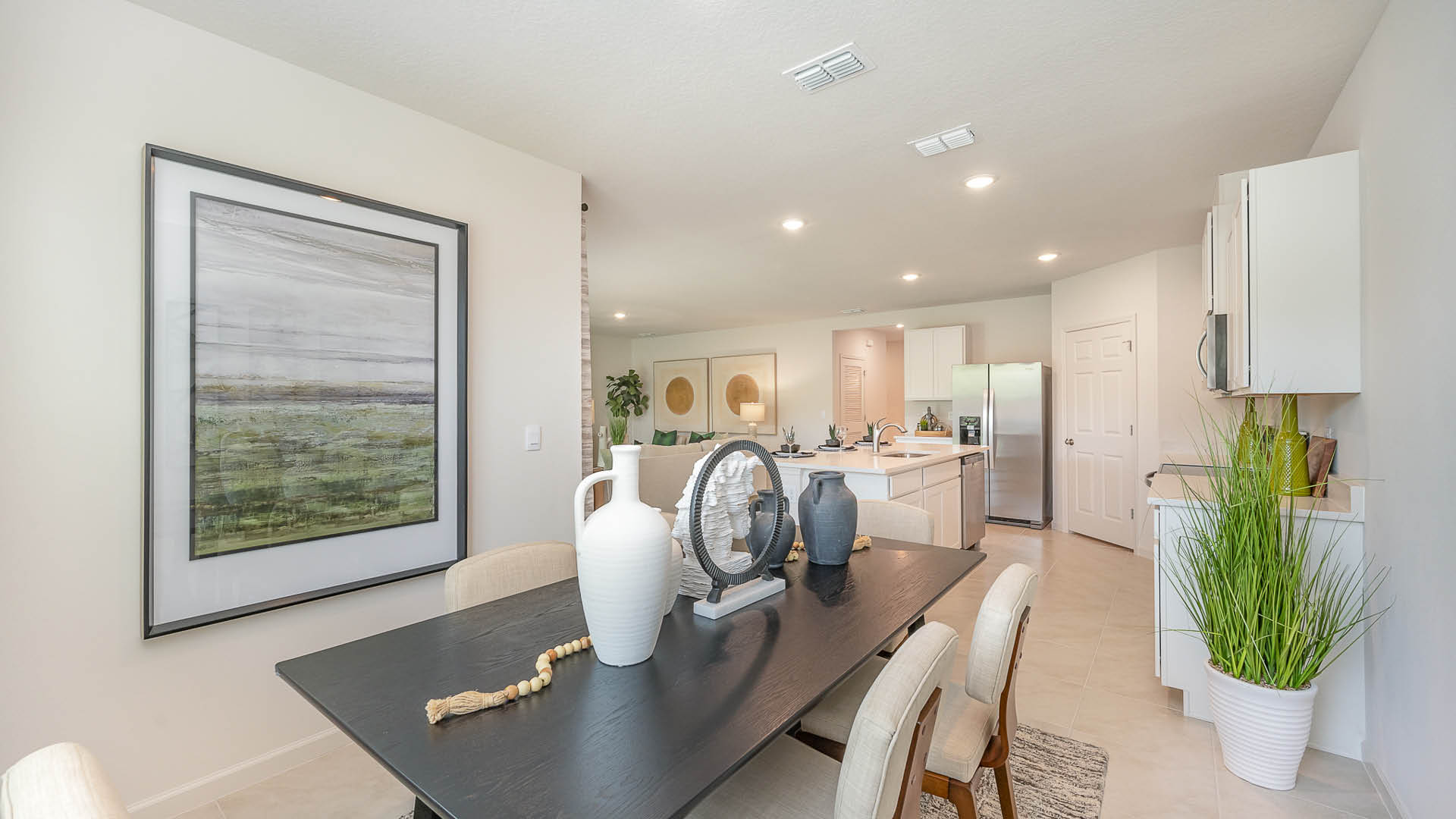 Spacious, light-filled living area with light-colored walls and modern flooring leading to a contemporary kitchen.
