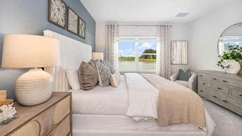 Cozy bedroom with a light color scheme, decorative pillows, large window view, and stylish furniture, creating a serene atmosphere.