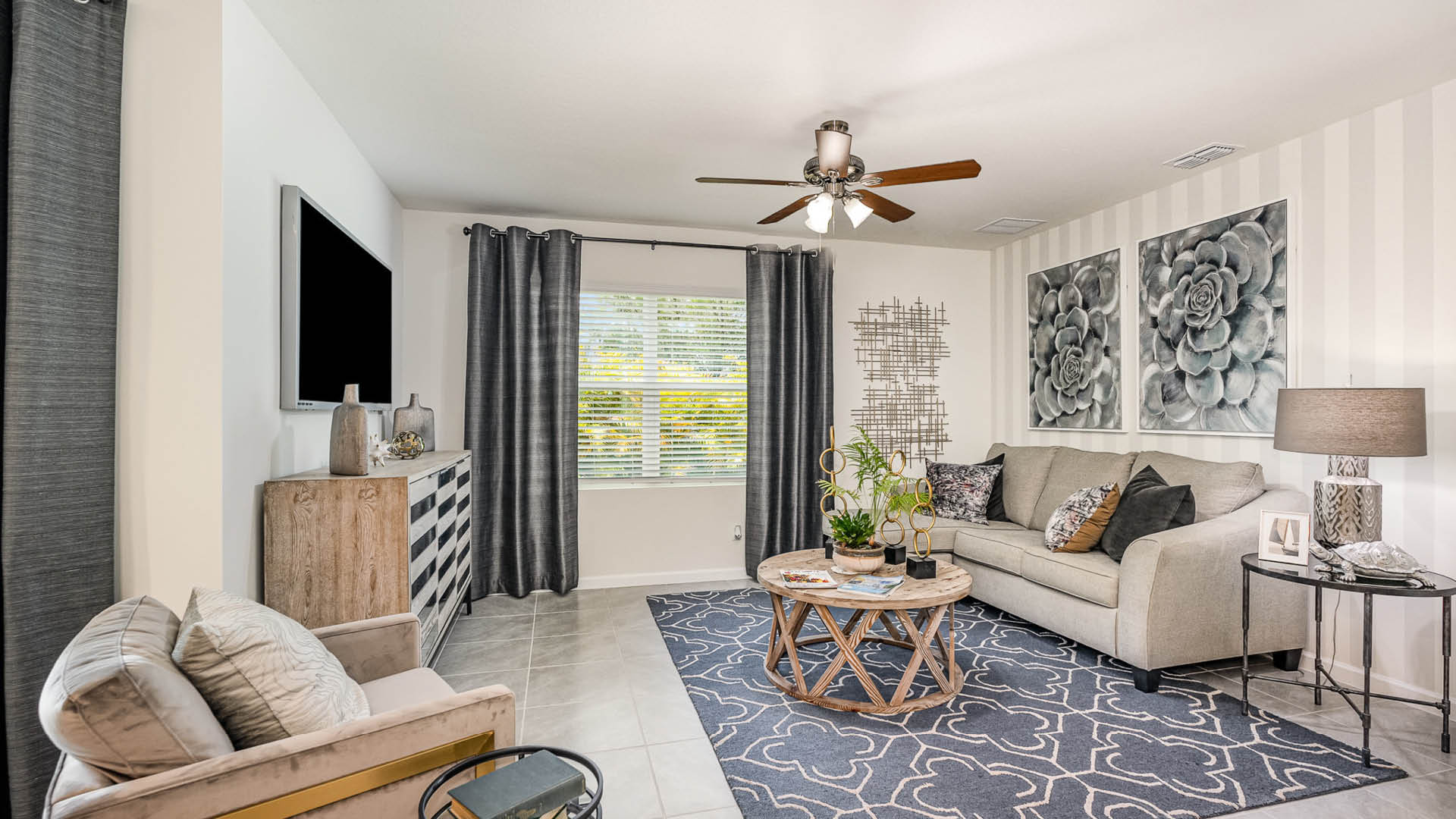 Modern living room featuring a light sofa, decorative pillows, large artwork, a round coffee table, and stylish curtains.