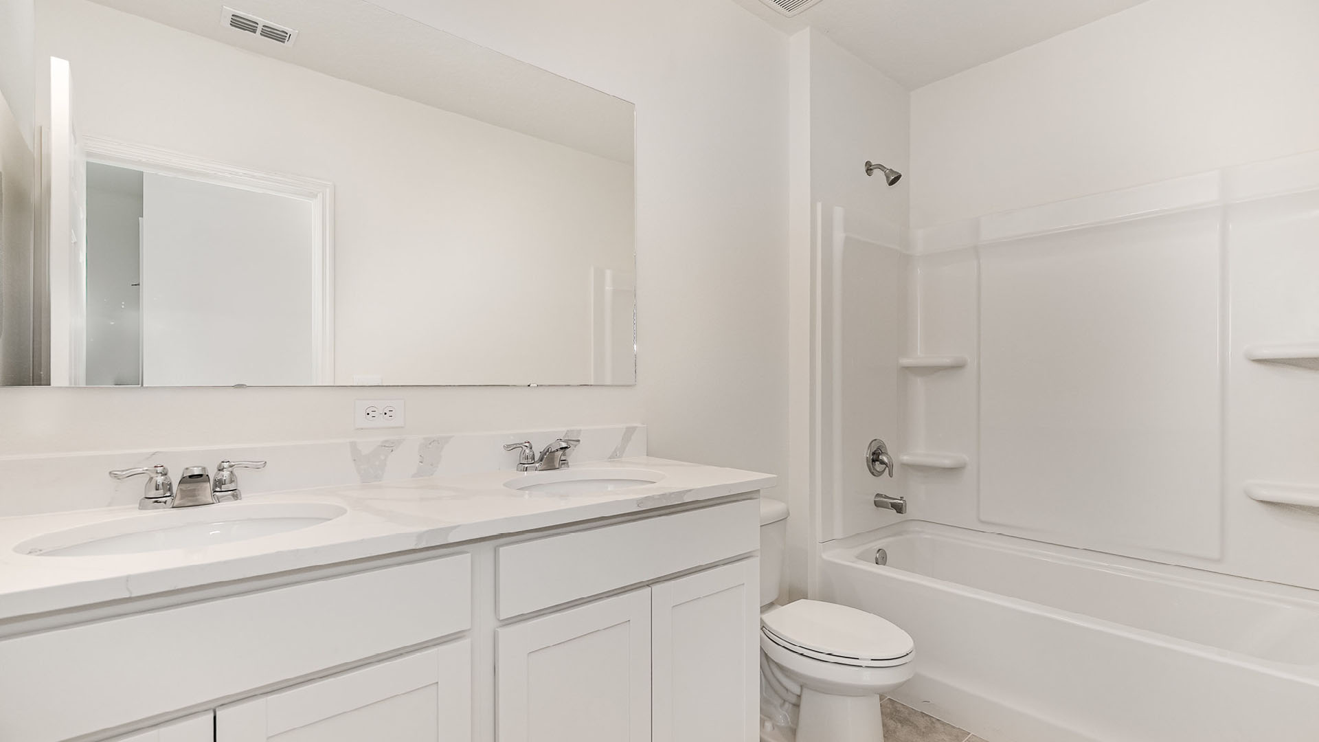 Modern bathroom featuring double sink vanity, large mirror, white cabinetry, and a bathtub with a shower. Bright, clean design.