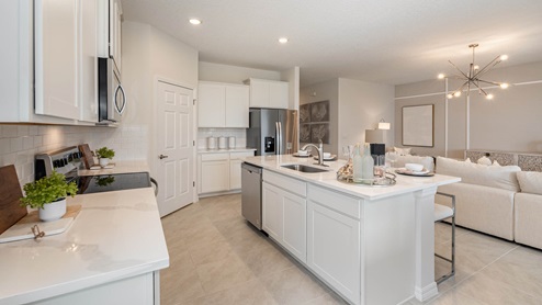Delray Kitchen featuring white cabinets, beautiful island and stainless appliances overlooking the living room