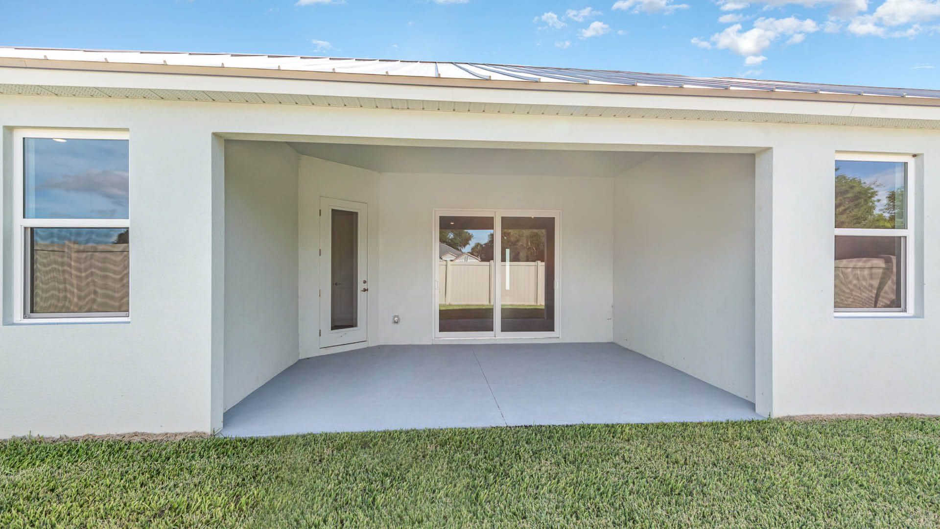 Covered patio with large sliding glass doors.