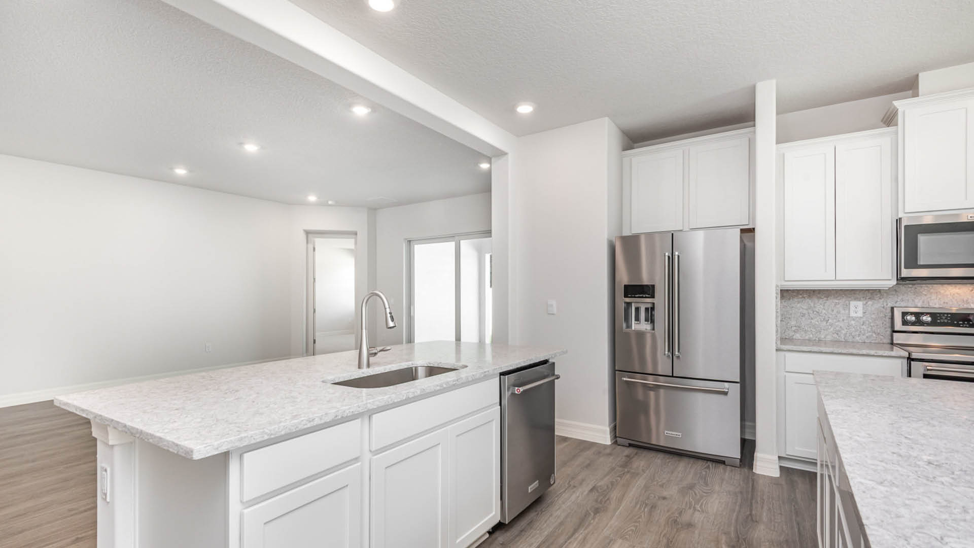 A bright white kitchen featuring sleek stainless steel appliances and a clean, modern design.