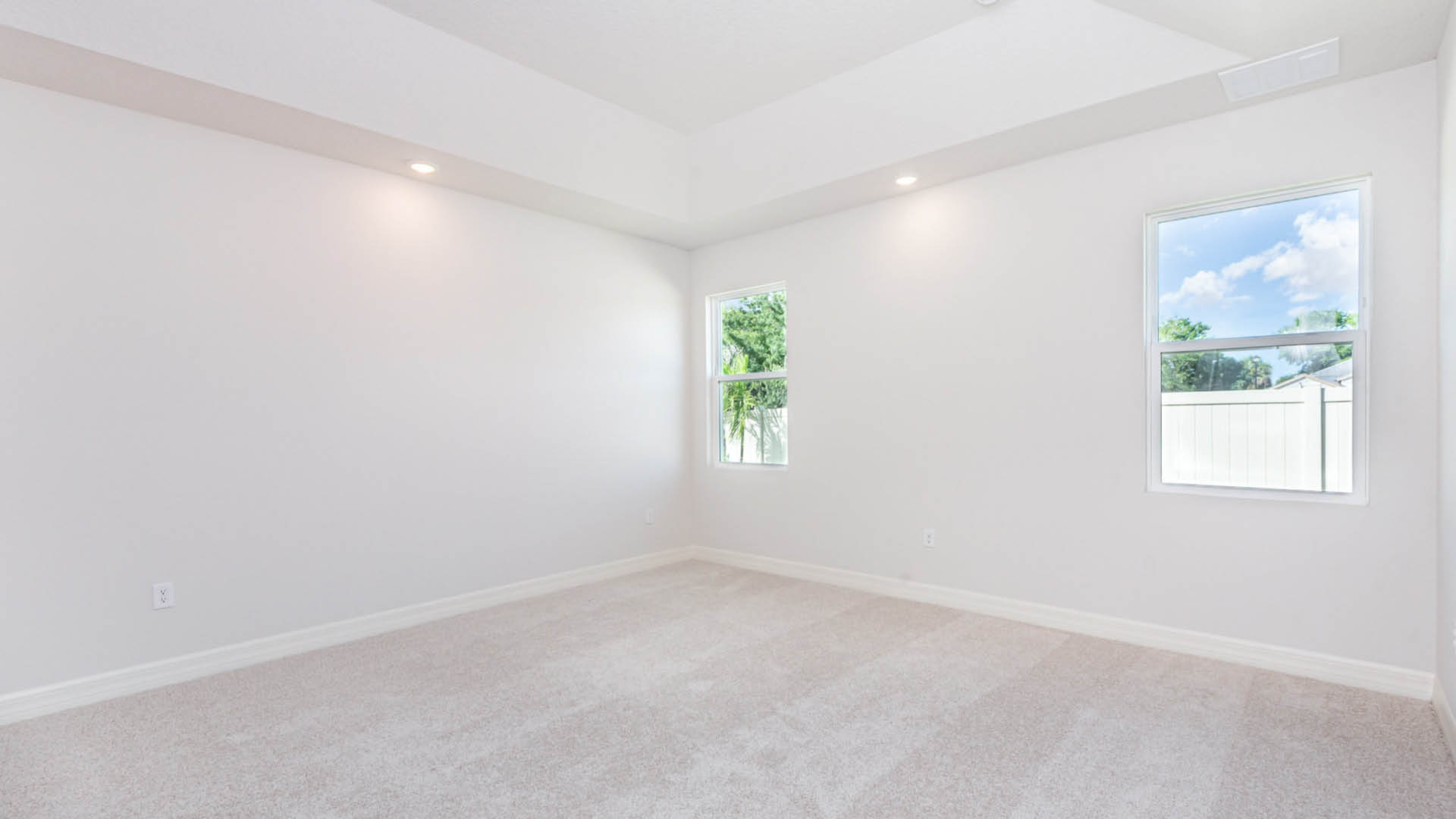 Empty room featuring white walls and soft carpeting, creating a bright and spacious atmosphere.