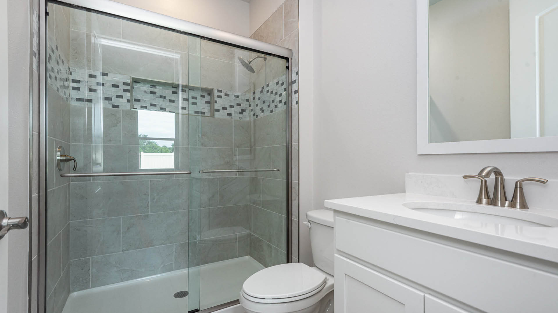 Bathroom featuring a shower, toilet, and sink, designed for functional and efficient use of space.