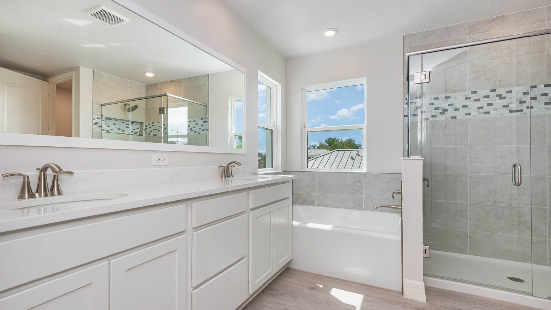 Interior view of a bathroom with a shower, sink, and tub, highlighting a functional and stylish layout.