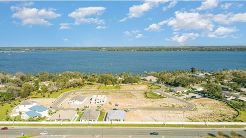 Aerial view of community showing location to the river and several completed homes.