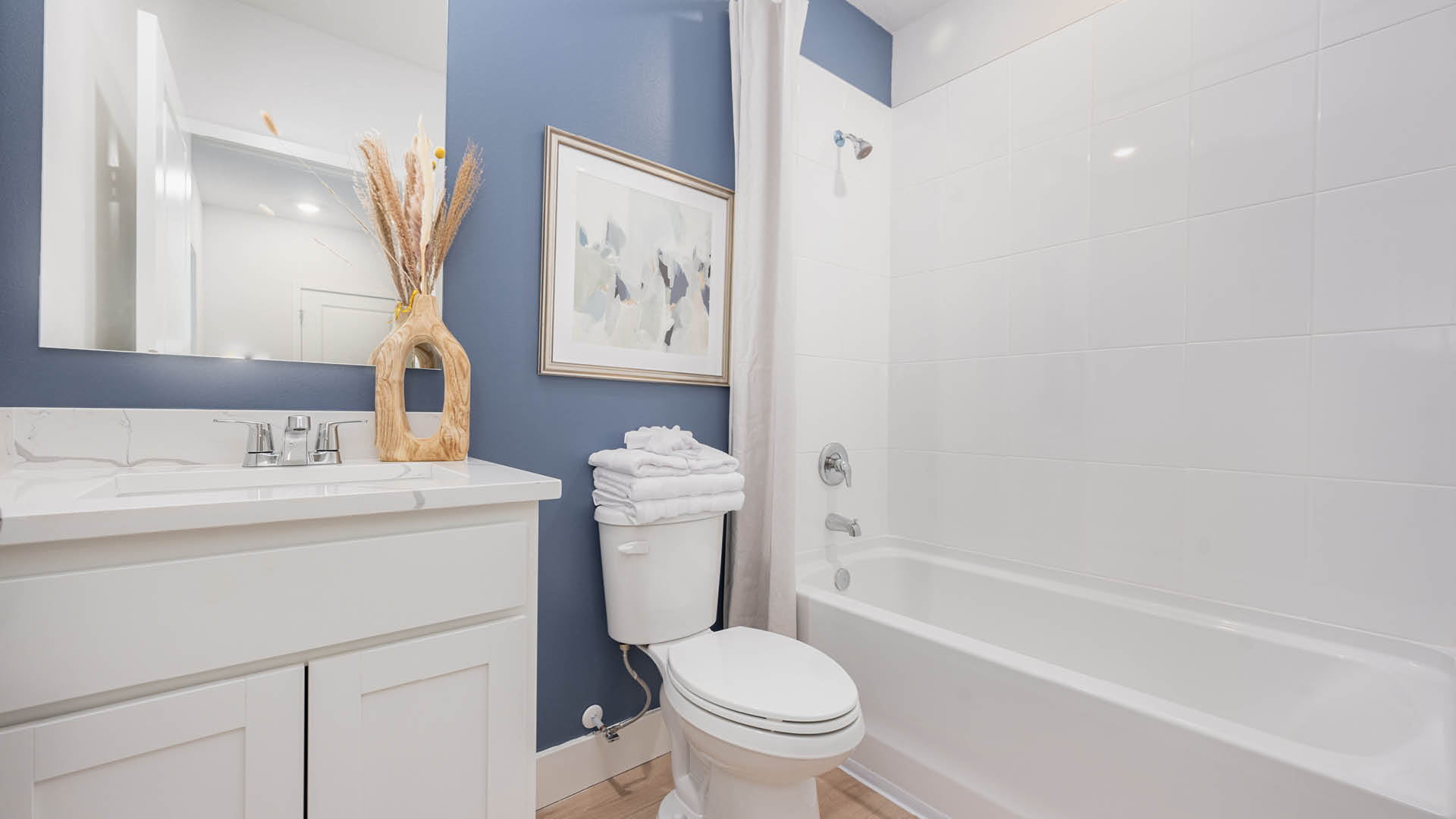 Secondary bathroom with quartz countertops, undermount sink and bathtub.