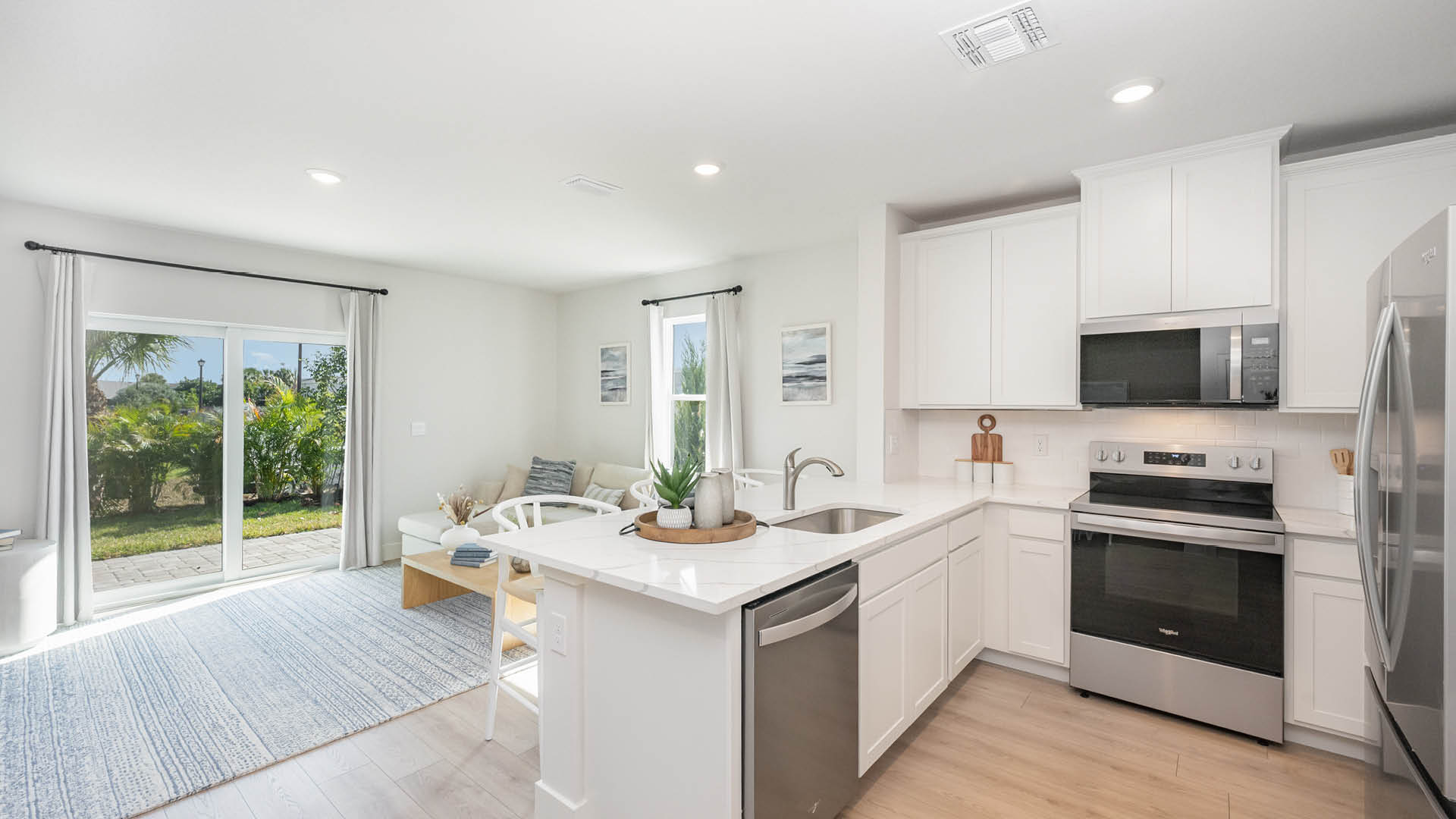 Bright, modern kitchen featuring stainless steel appliances, white cabinetry, and a cozy dining area with natural light.