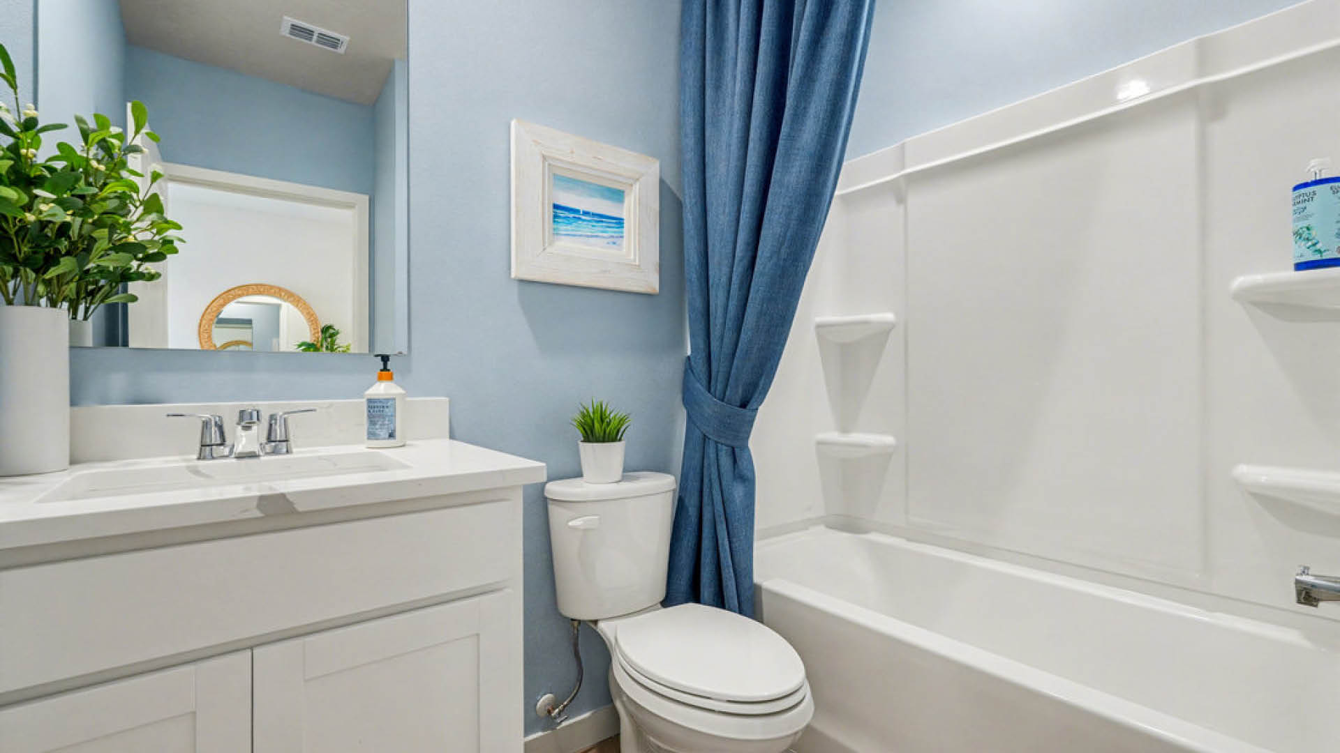 A bathroom featuring blue curtains and a white toilet, creating a clean and simple aesthetic.