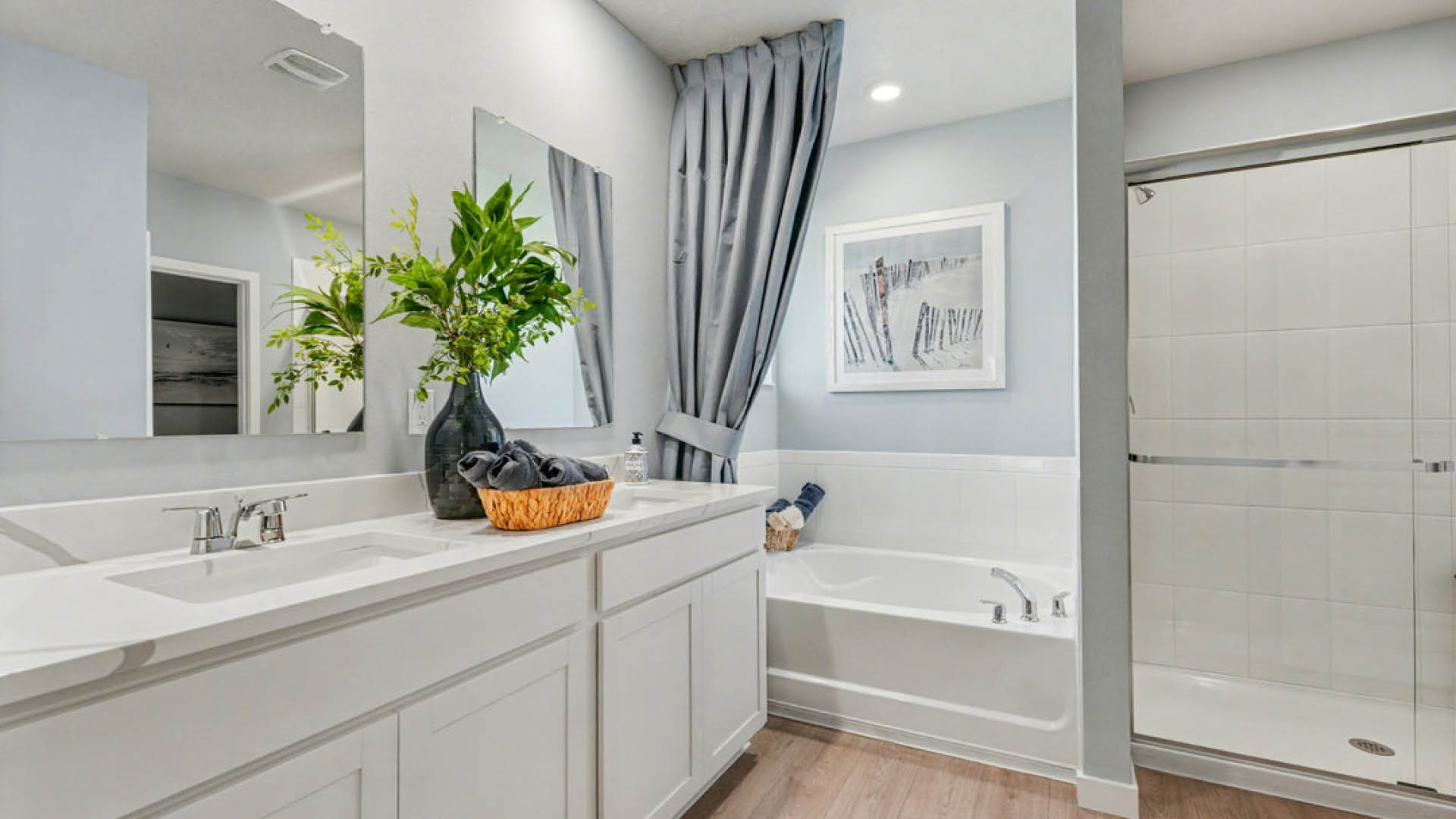 Clean bathroom featuring a shower, sink, and tub, with modern fixtures and bright lighting.