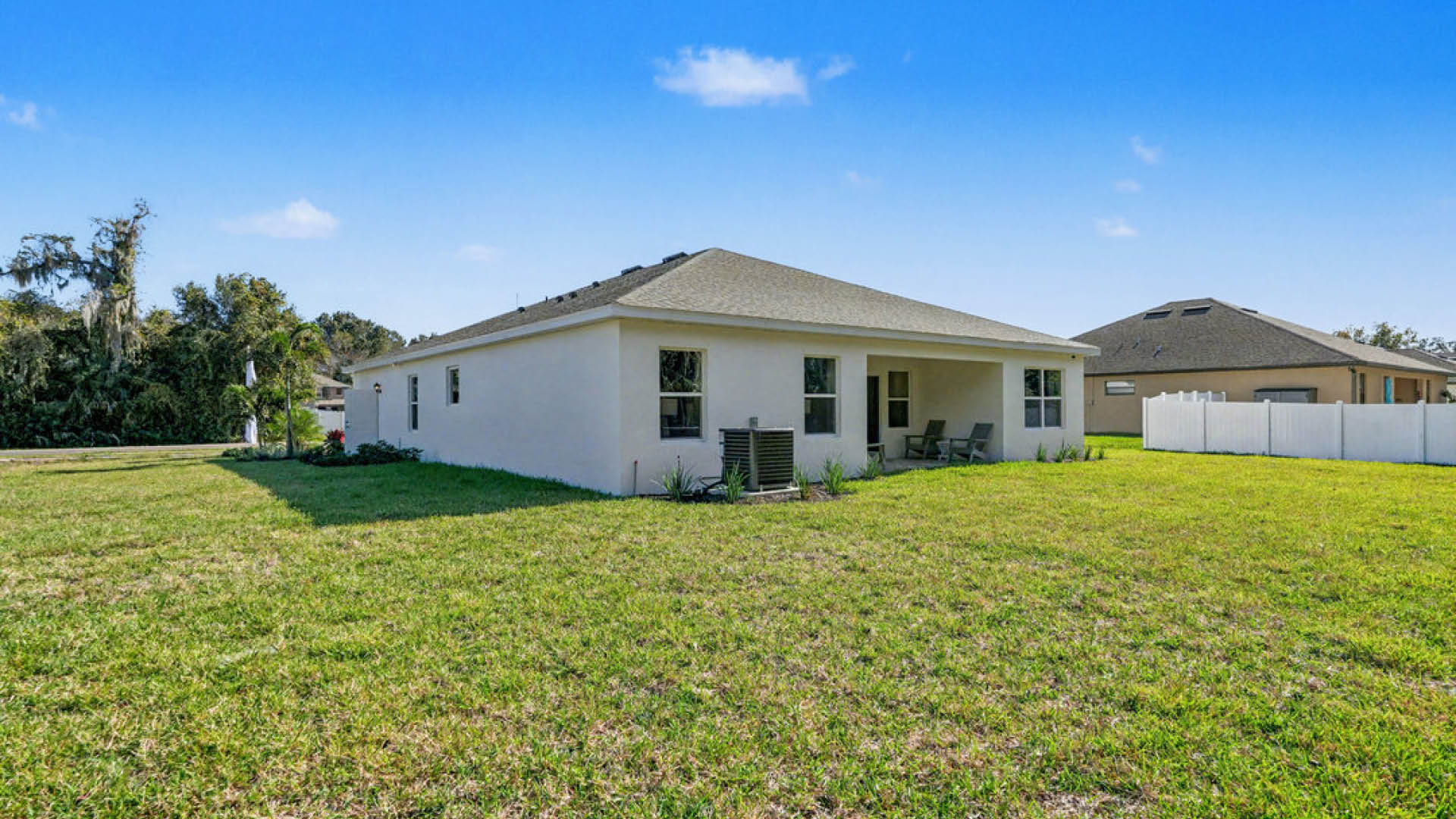 A house with a fenced yard, featuring a white fence surrounding the property.