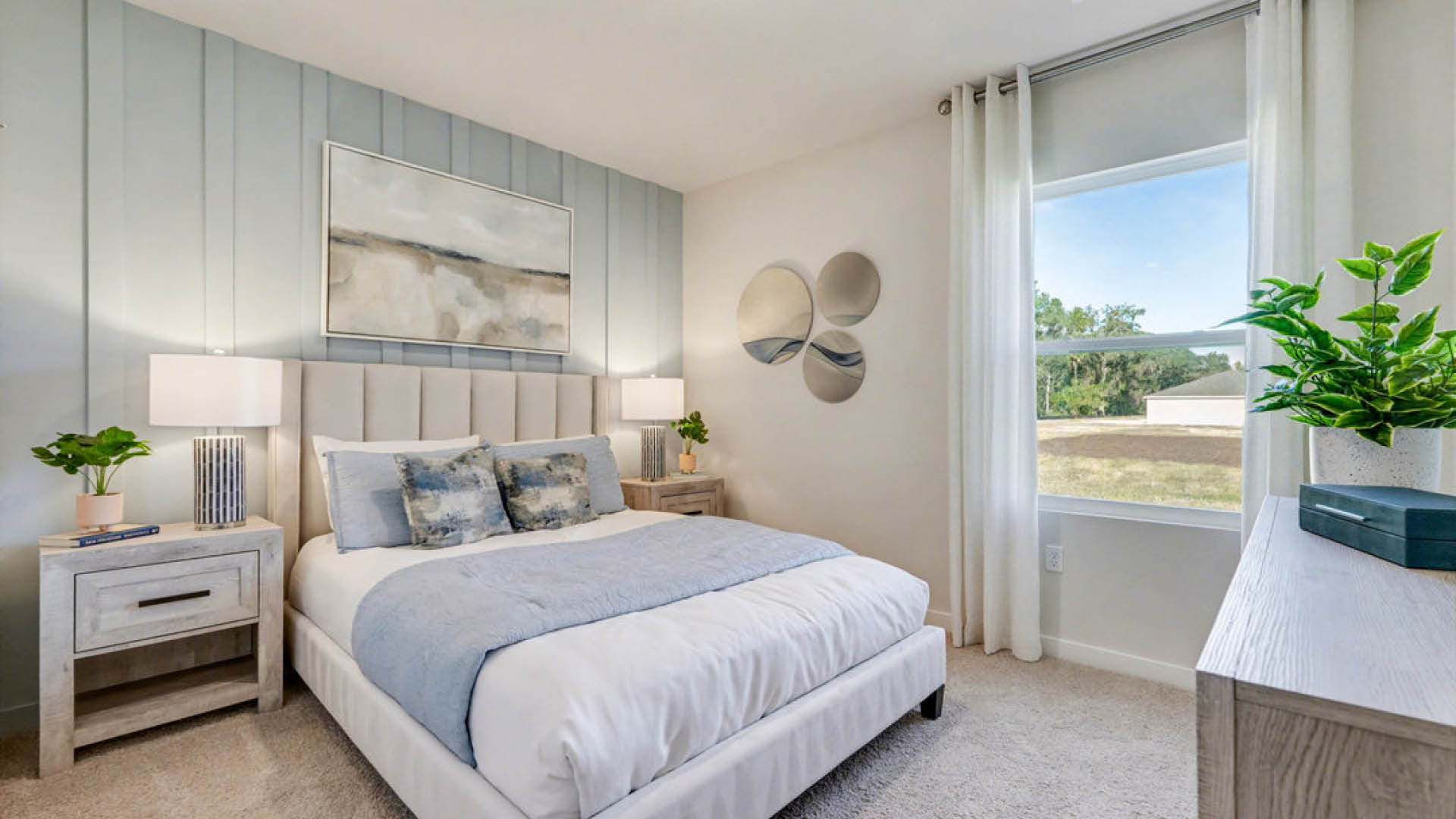 A cozy bedroom featuring a bed, a nightstand, and a window allowing natural light to enter the space.