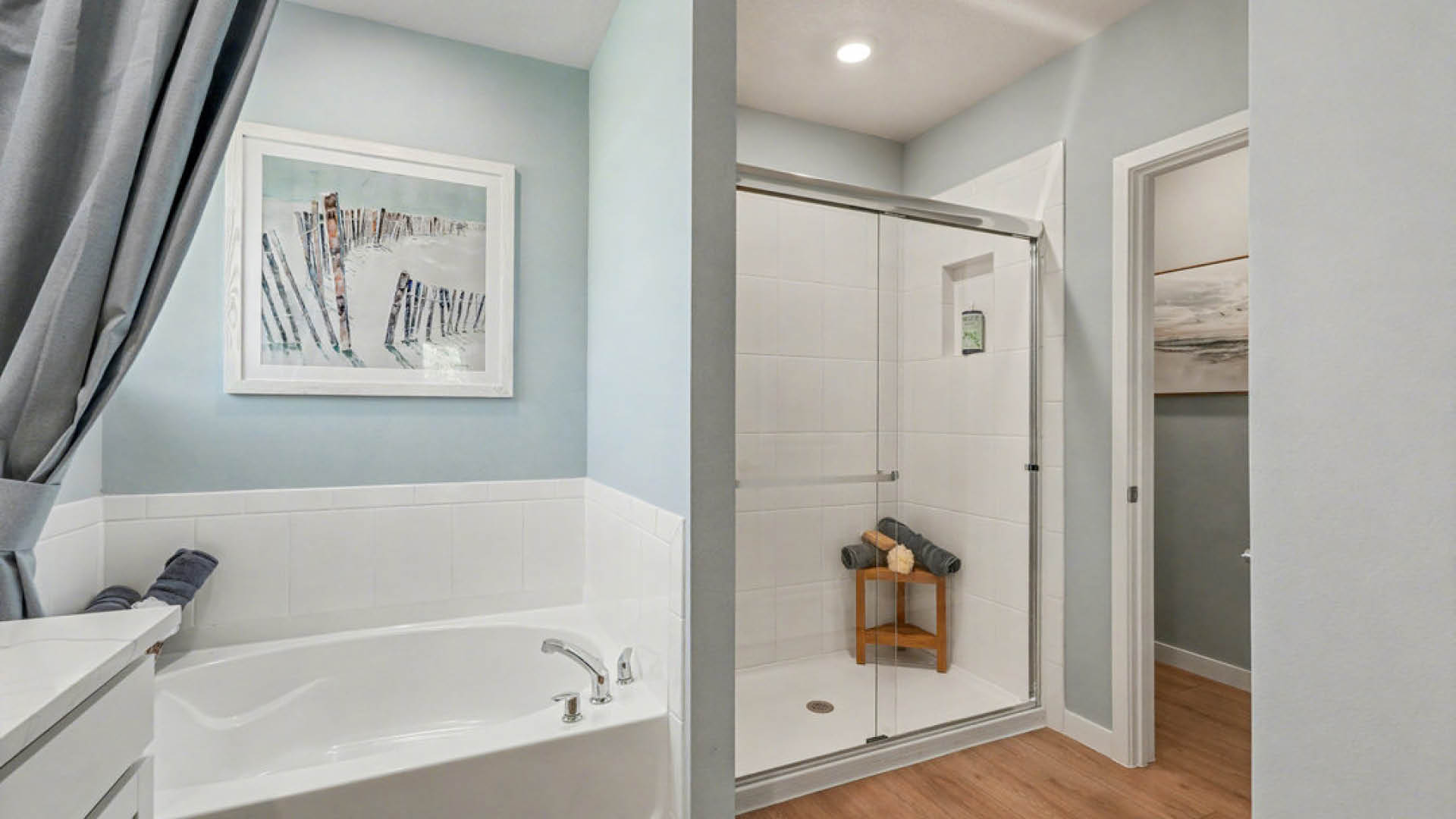 A clean bathroom featuring a shower, toilet, and sink, with neutral-colored tiles and modern fixtures.