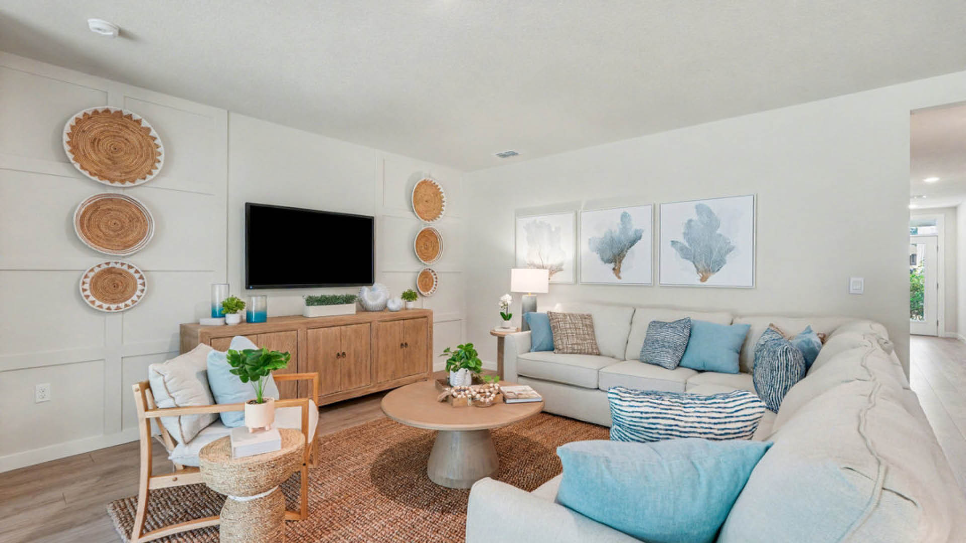 A cozy living room featuring a couch, coffee table, and a television against a neutral wall.